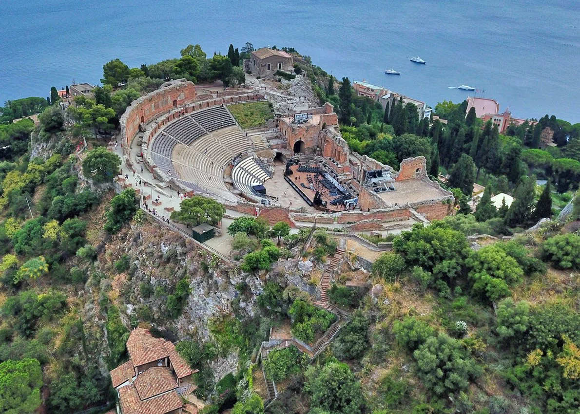 A sweeping wide-angle view of the ancient Greek-Roman Theatre of Taormina in Sicily, Italy