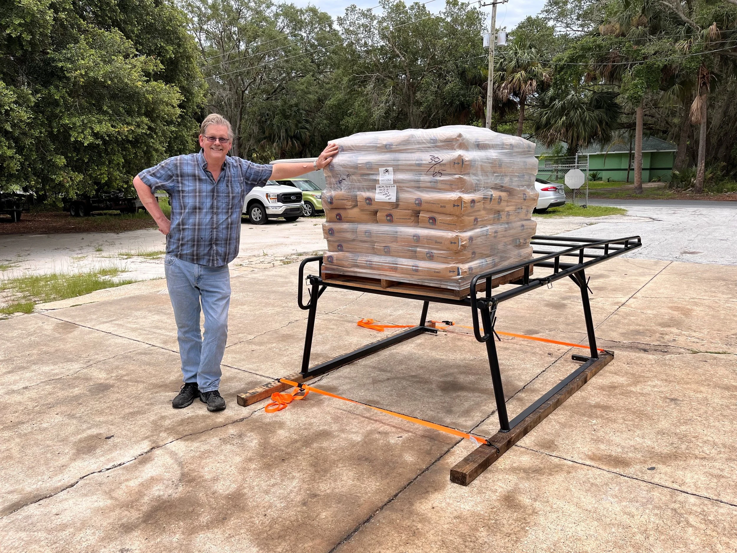 Sterling Equipment's owner posing with 3,500 lbs of sand on a Sterling Truck Rack