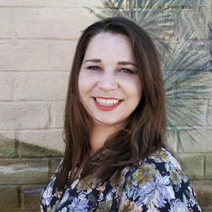 smiling woman with flowers on shirt kind