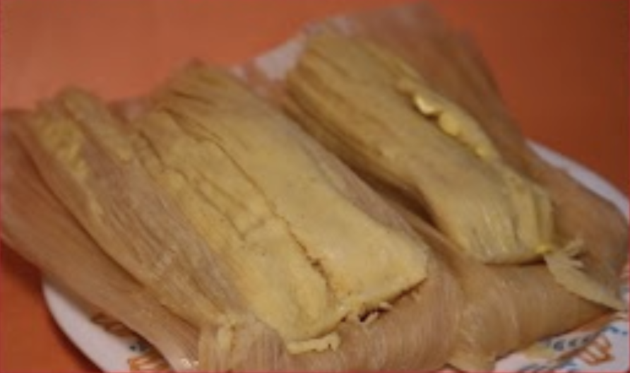 Photo of a tamale on an orange table.