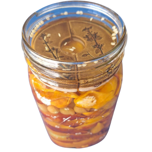 A jar of yellow colored fermenting foods