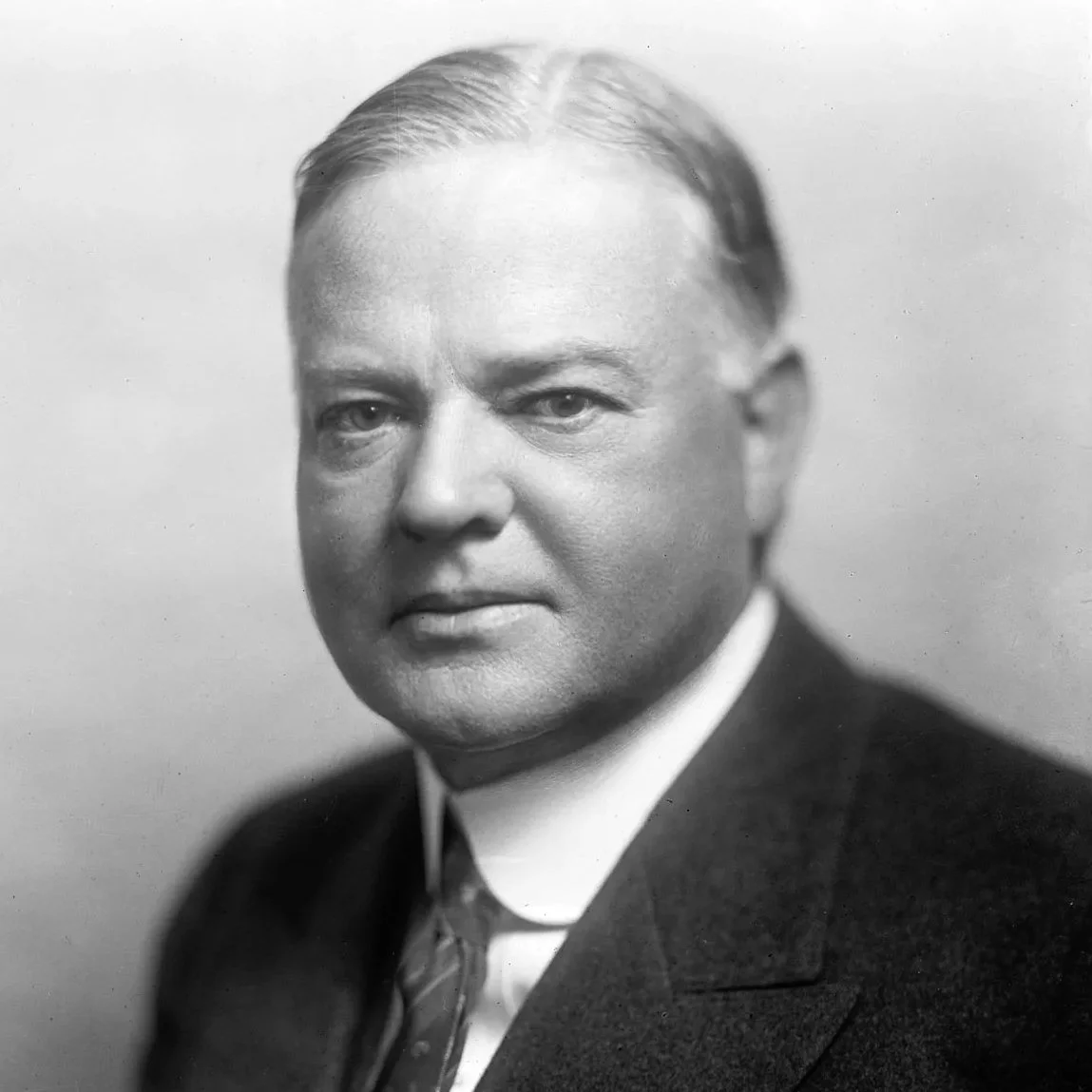 Black and white portrait of a distinguished middle-aged man in a suit and tie.