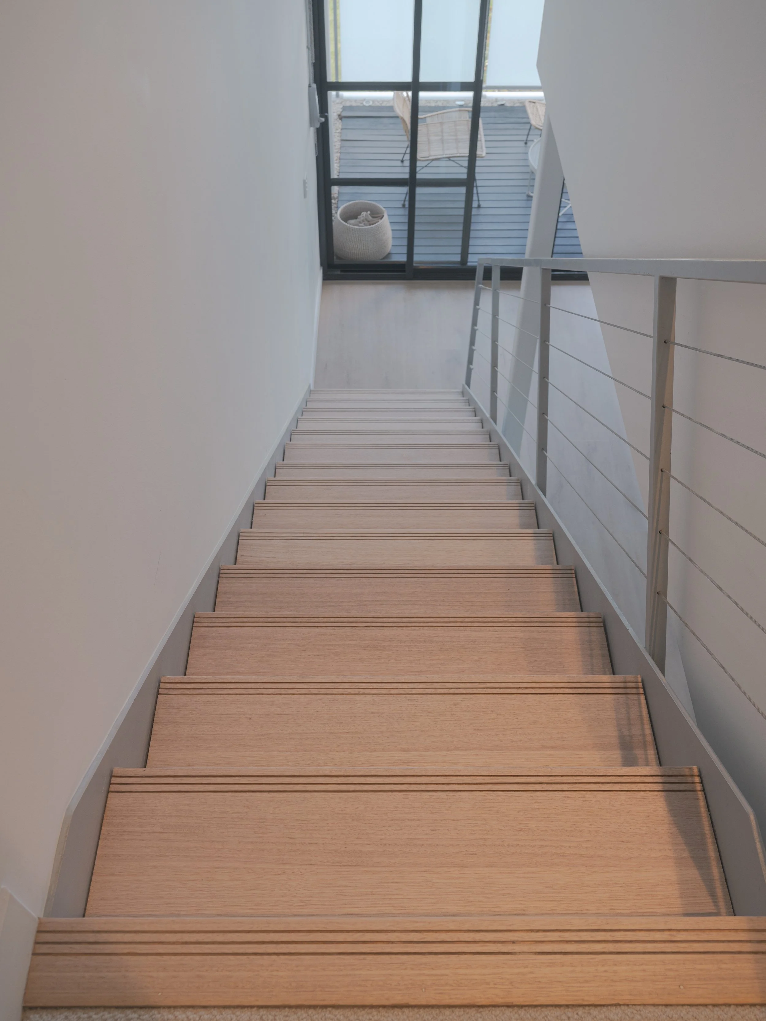 Wooden staircase with a white wall background