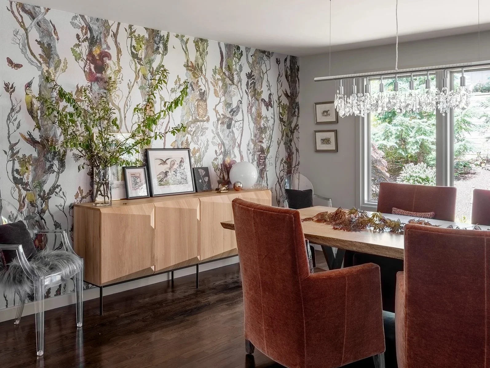 A dining room with a wooden dining table surrounded by red upholstered chairs, and Timorous Beasties Wallpaper. Seattle, Mecer Island, Remodel.