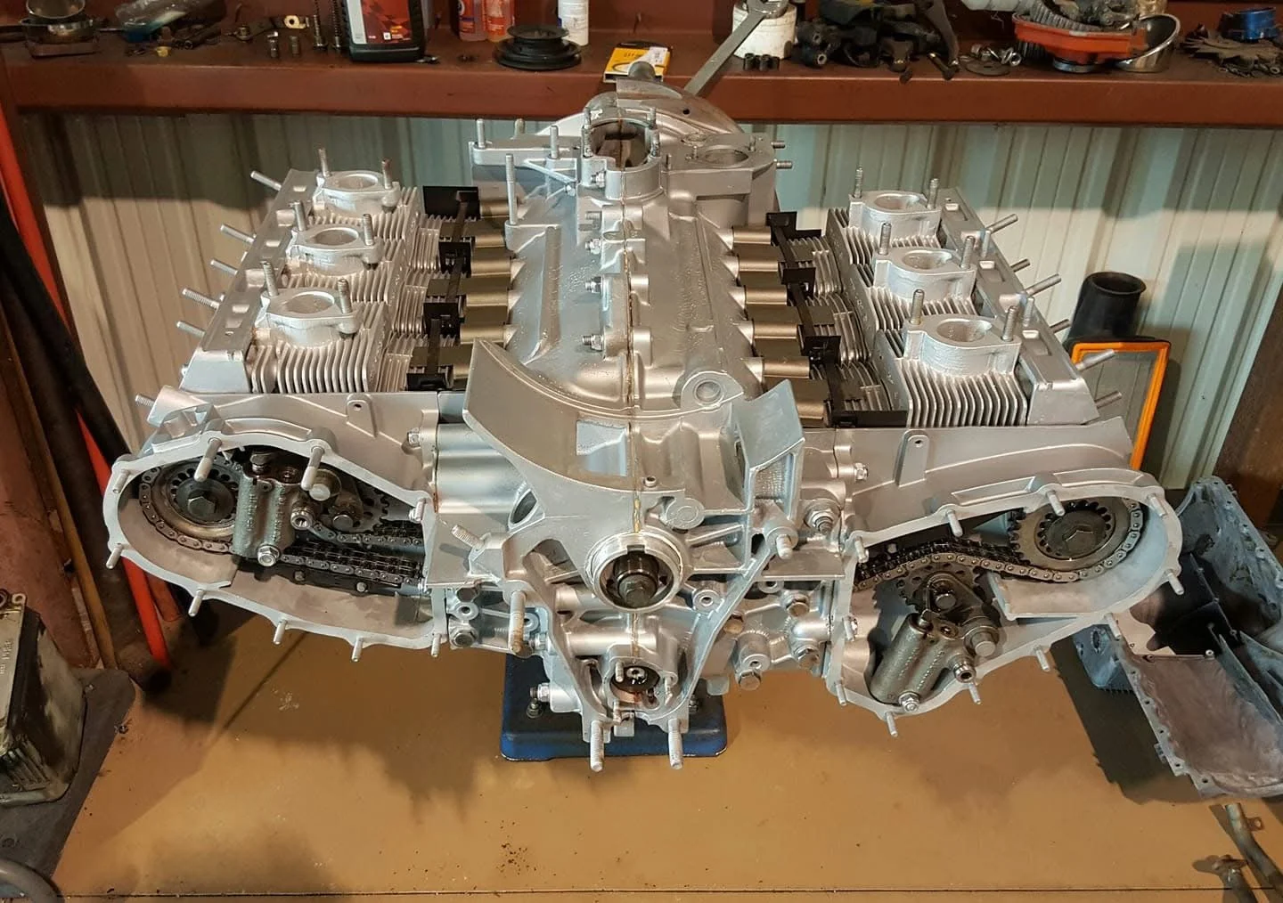Open Porsche engine in a workshop with visible pistons and timing chains
