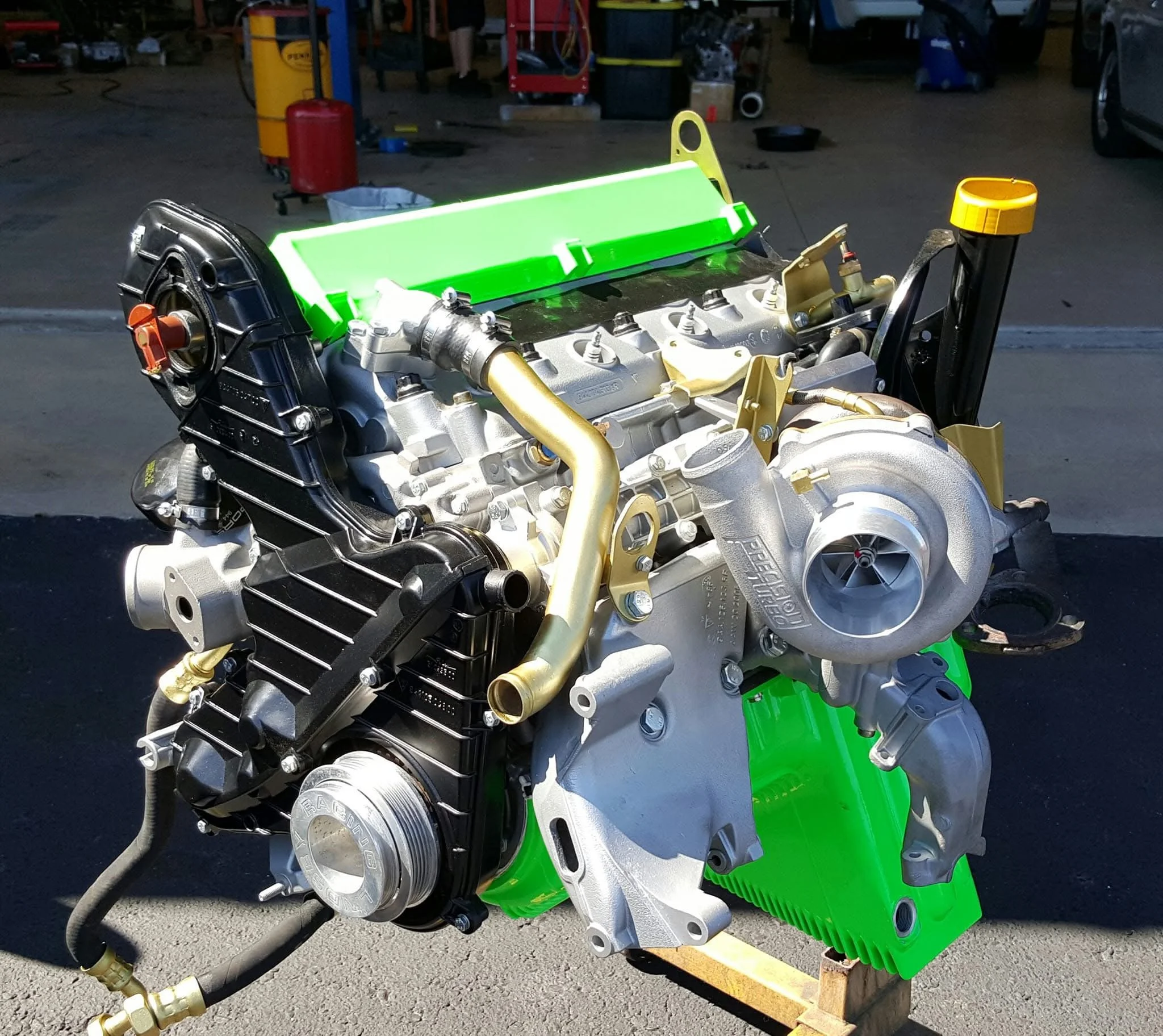 High-performance car engine with turbocharger on display in an automotive shop.