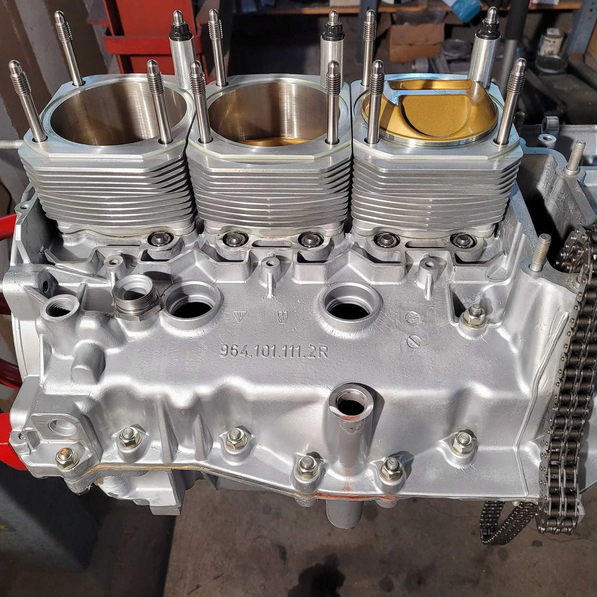 Close-up of a partially assembled car engine with visible pistons and cylinders.