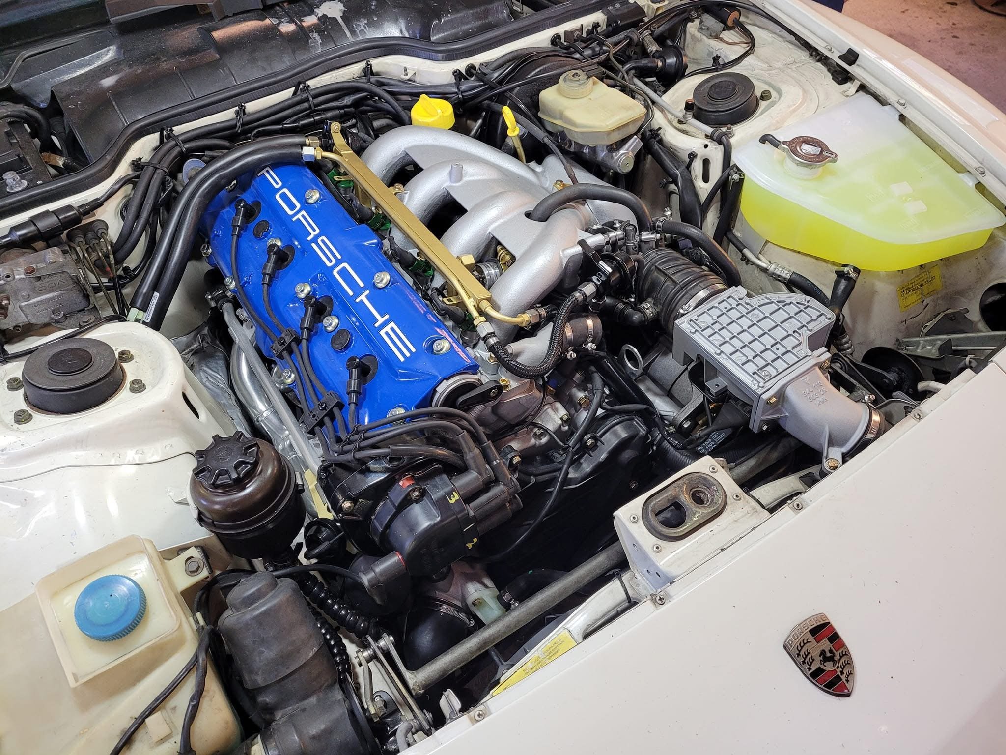 Porsche engine compartment with a blue valve cover.