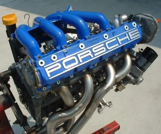 Porsche engine with blue manifold and exhaust headers.