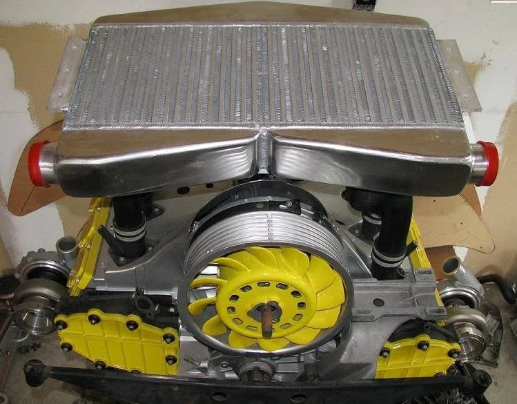 Porsche 911 flat-six engine with yellow cooling fan and intercooler