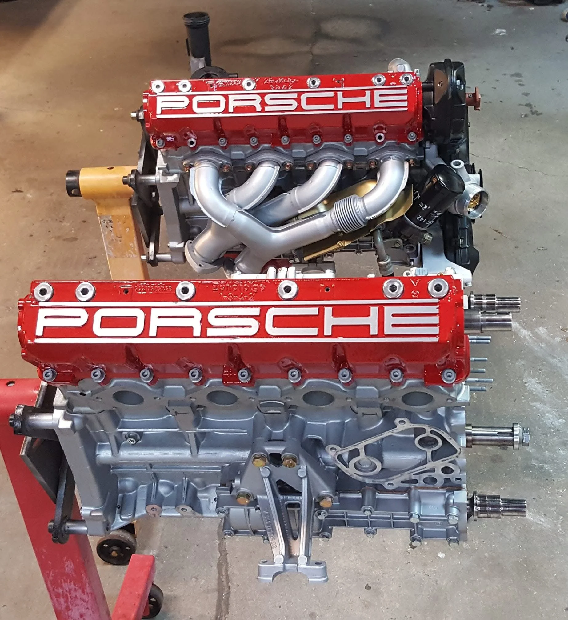 Porsche engine with red valve covers on an engine stand