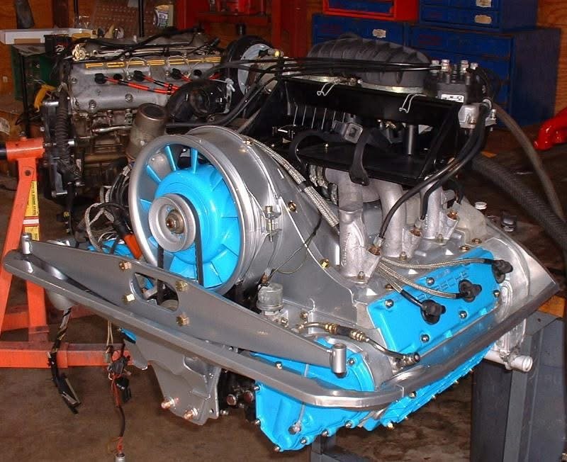 High-performance Porsche 911 engine on a stand in a workshop.