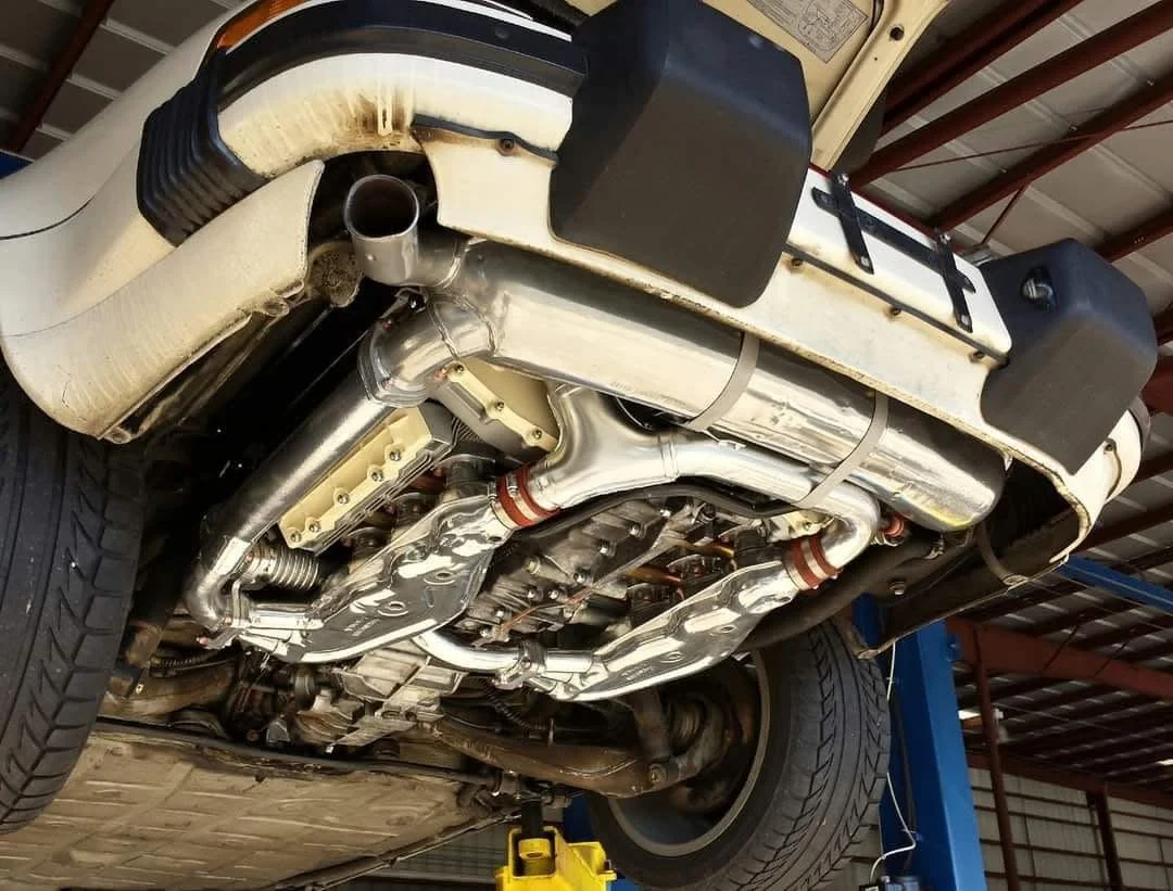 View of an elevated car from underneath showing exhaust system.