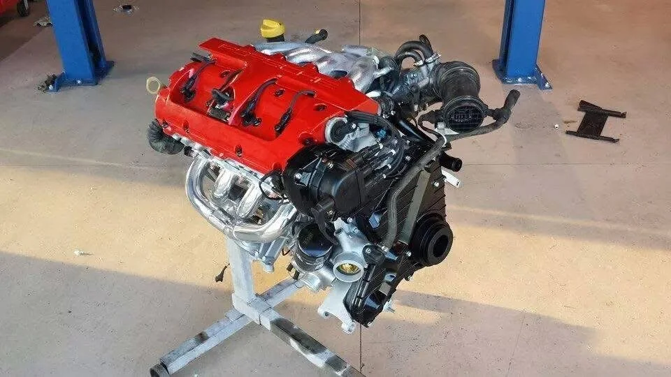 Automobile engine on stand, red valve cover