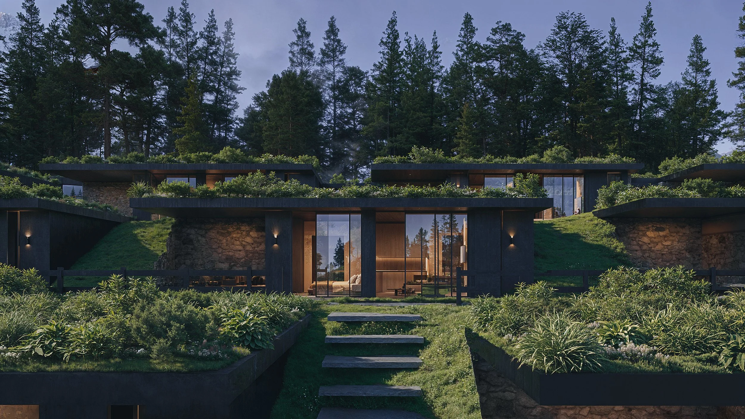 Modern multi-level house with large glass windows, surrounded by greenery and tall trees, set against a forested hillside, during twilight.