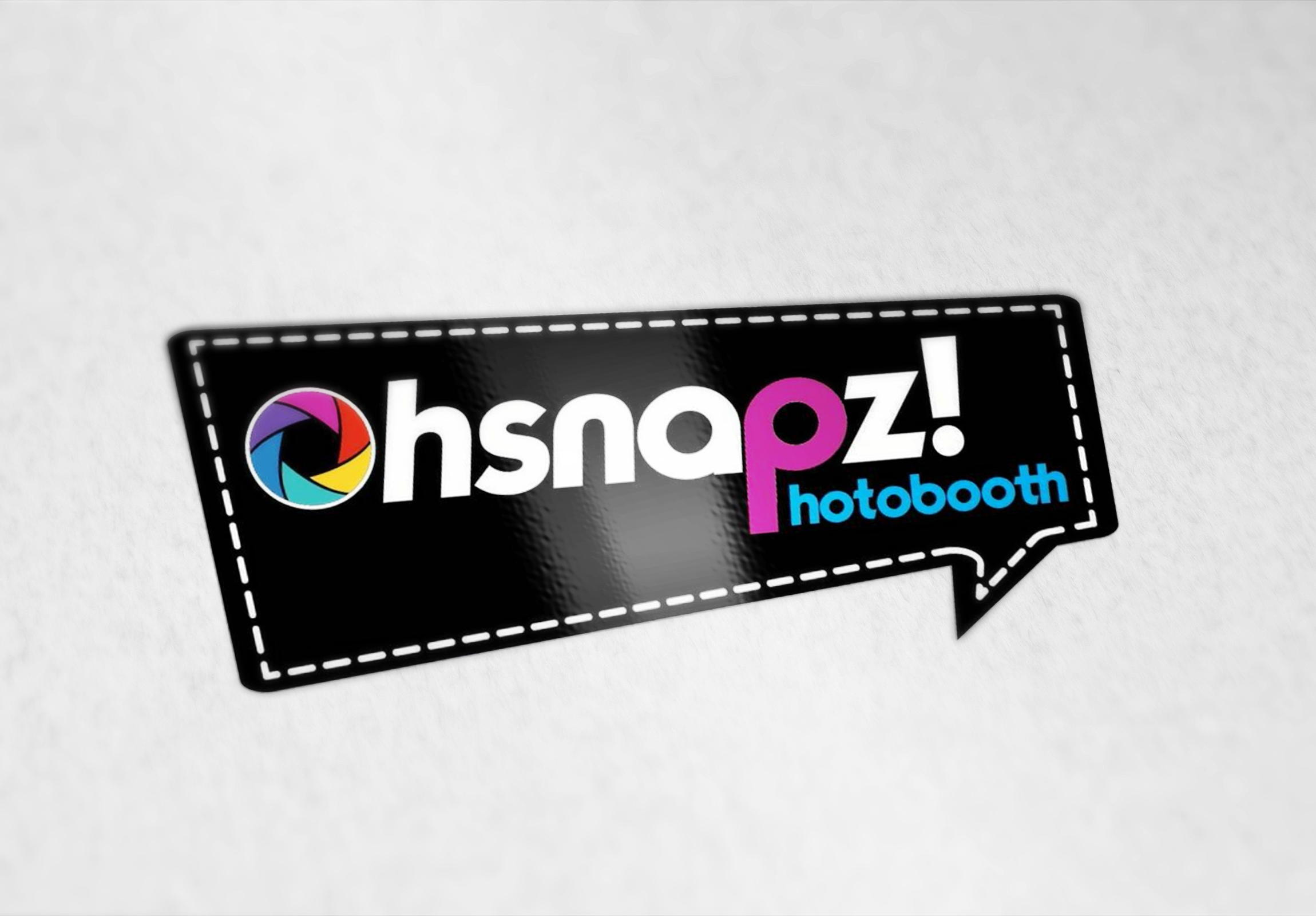 Logo design for "hsnapz photobooth" with a colorful camera aperture icon on a black speech bubble background.