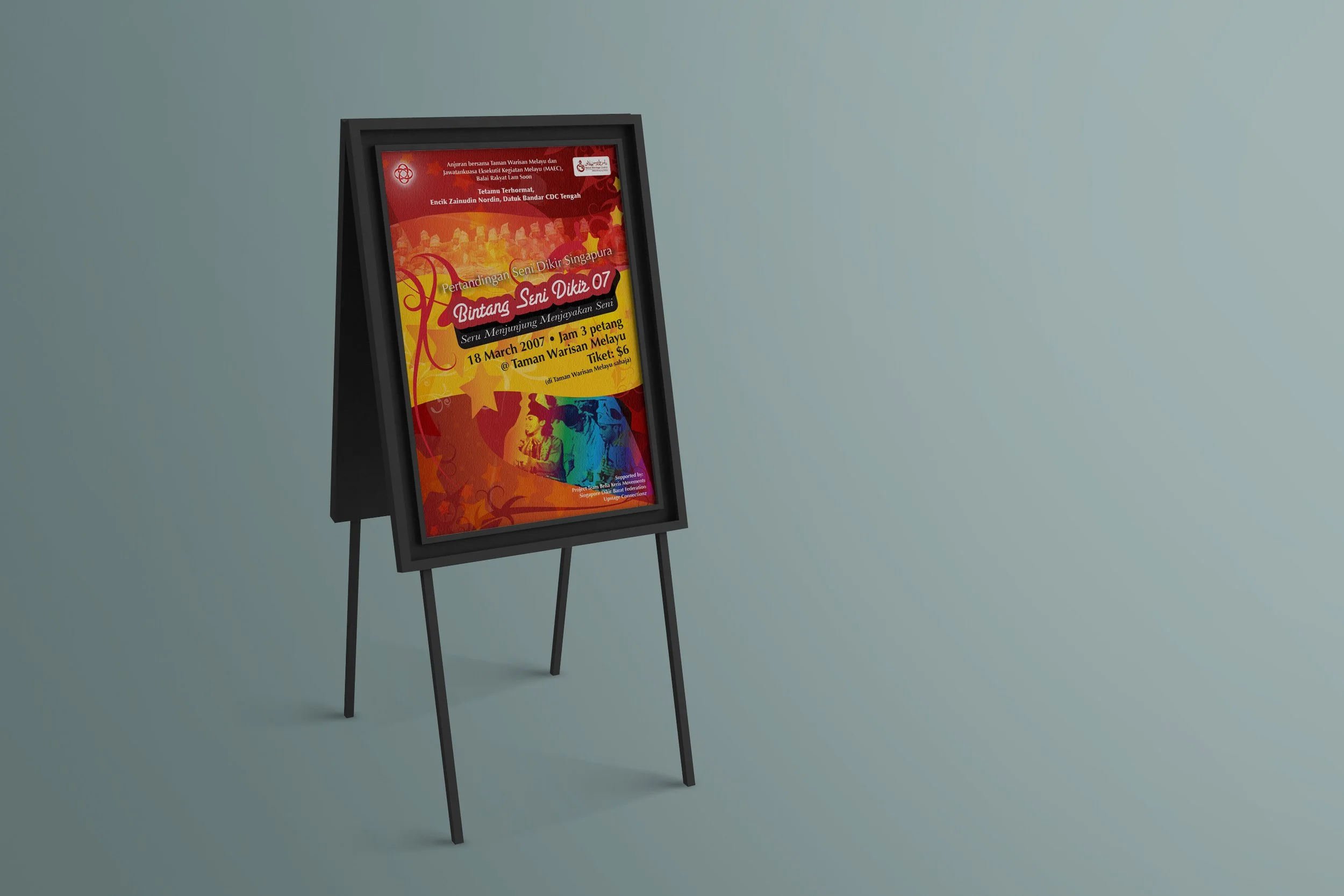 A framed poster on a stand, advertising an event titled "Pertandingan Seni Dikir Singapura Bintang Seni Dikir 07" scheduled for 18 March 2007 at Taman Warisan Melayu. The background is red with artistic patterns and includes event details in Malay.