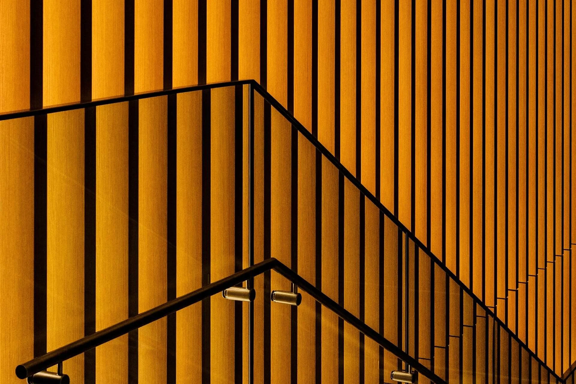 Facade with golden vertical slats and glass railing – photo by Milan Istvan