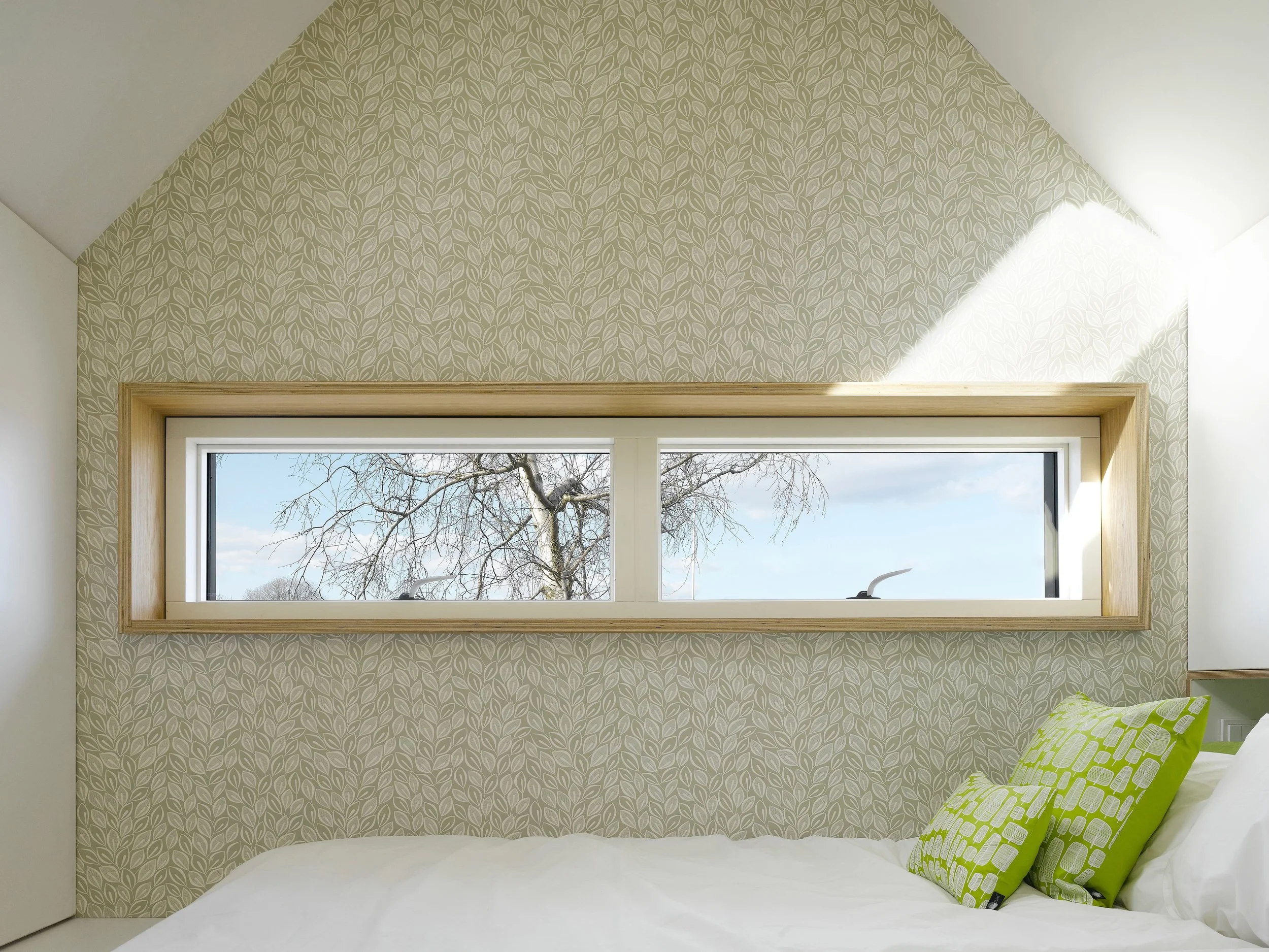 A bedroom with eco-wallpaper and natural internal finishes.