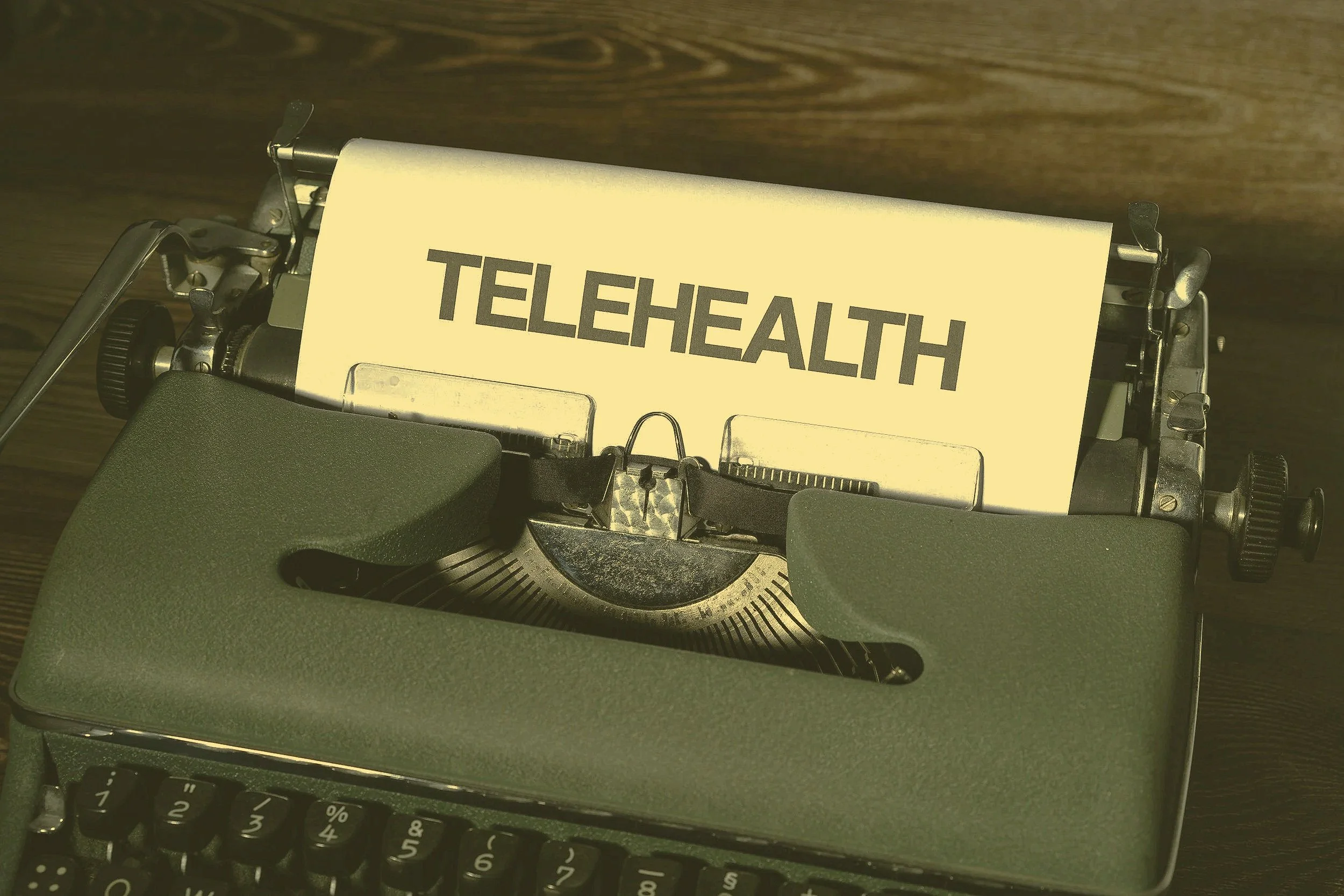 Typewriter with a sign that says TELEHEALTH