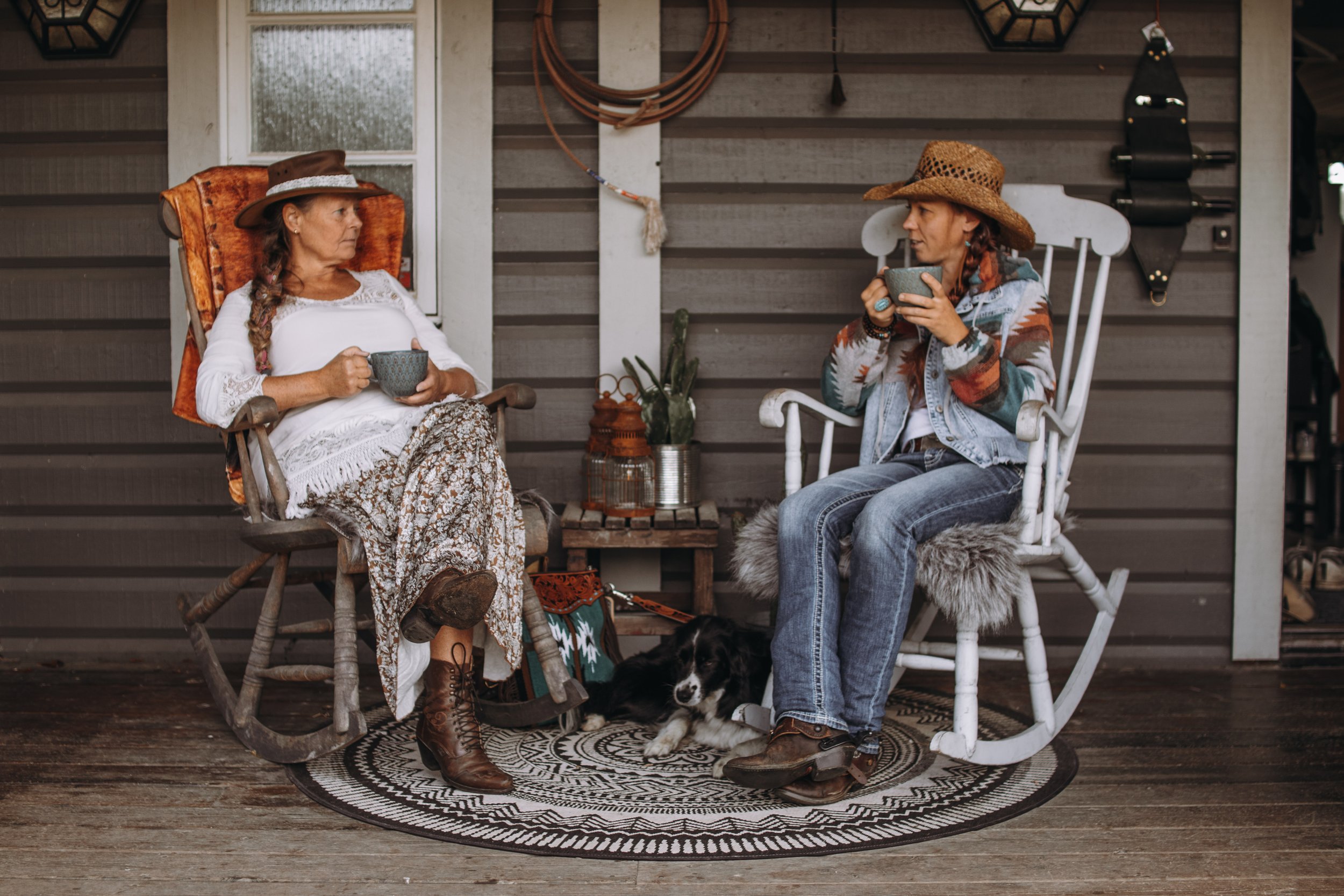 Två cowgirls sitter i varsin gungstol på saloonen och dricker kaffe