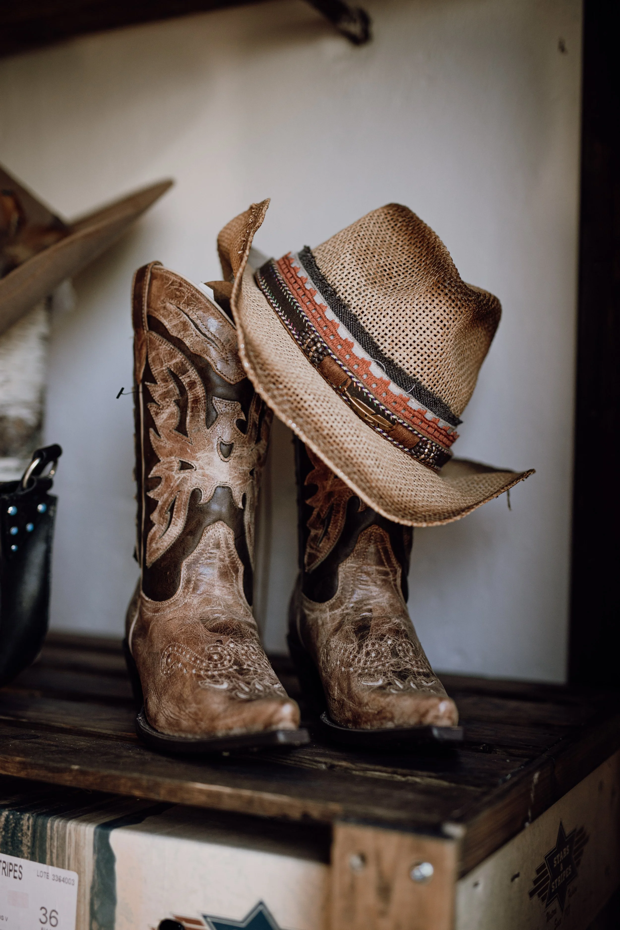 Ett par cowboy boots med en hatt som hänger på skaftet