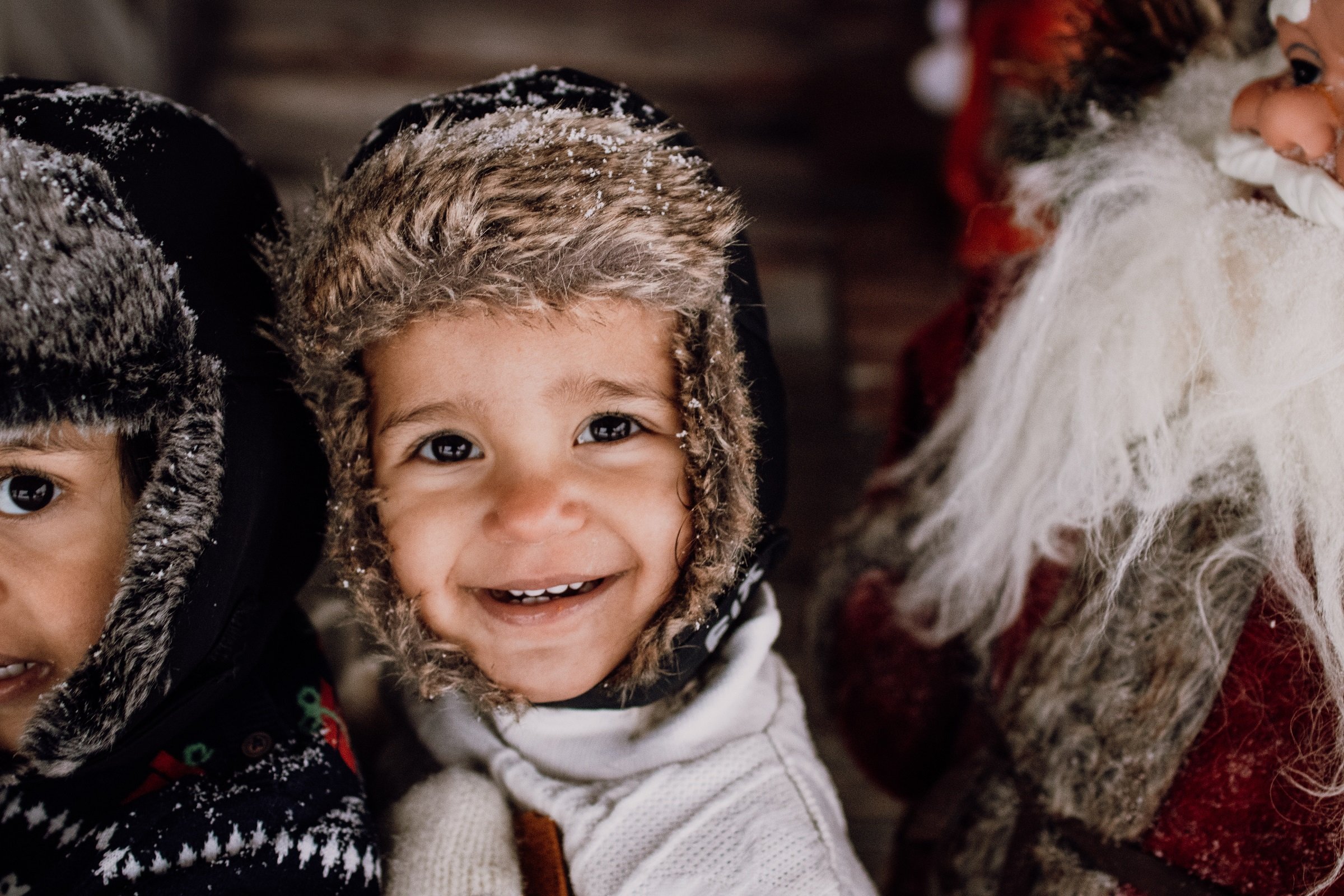 Bild på ett barn som ler stort och har på sig en varm mössa.