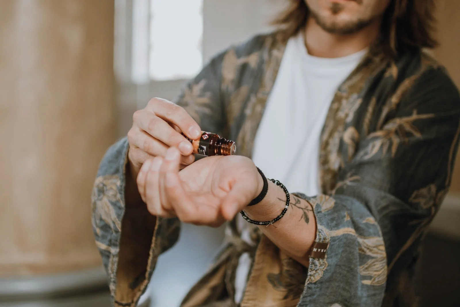 Person som applicerar växtbaserad olja eller essentiell olja på handryggen.