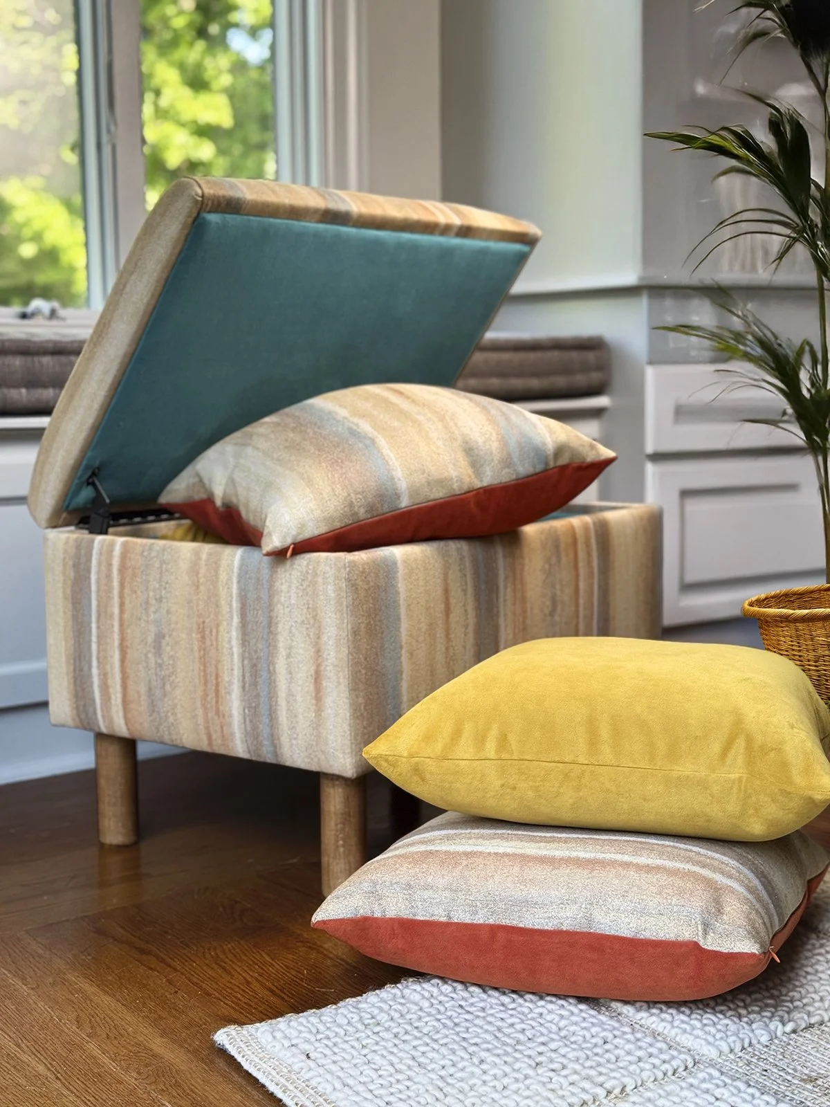 Multicolor modern storage ottoman with wooden legs and an open lid revealing plush velvet