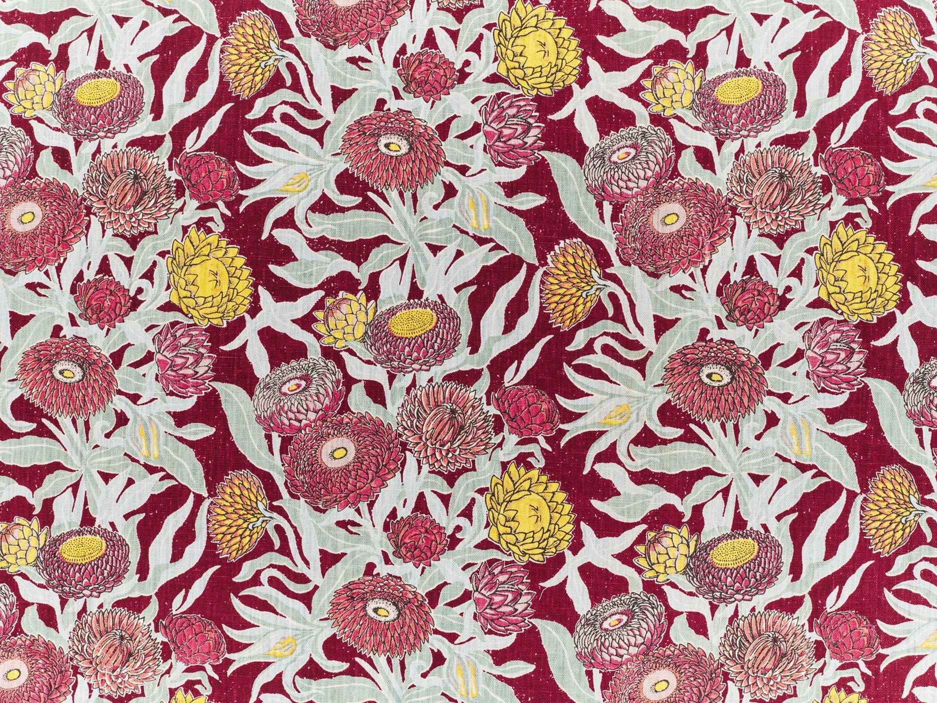 Fabric with a floral pattern featuring pink and yellow flowers with green leaves on a dark red background.
