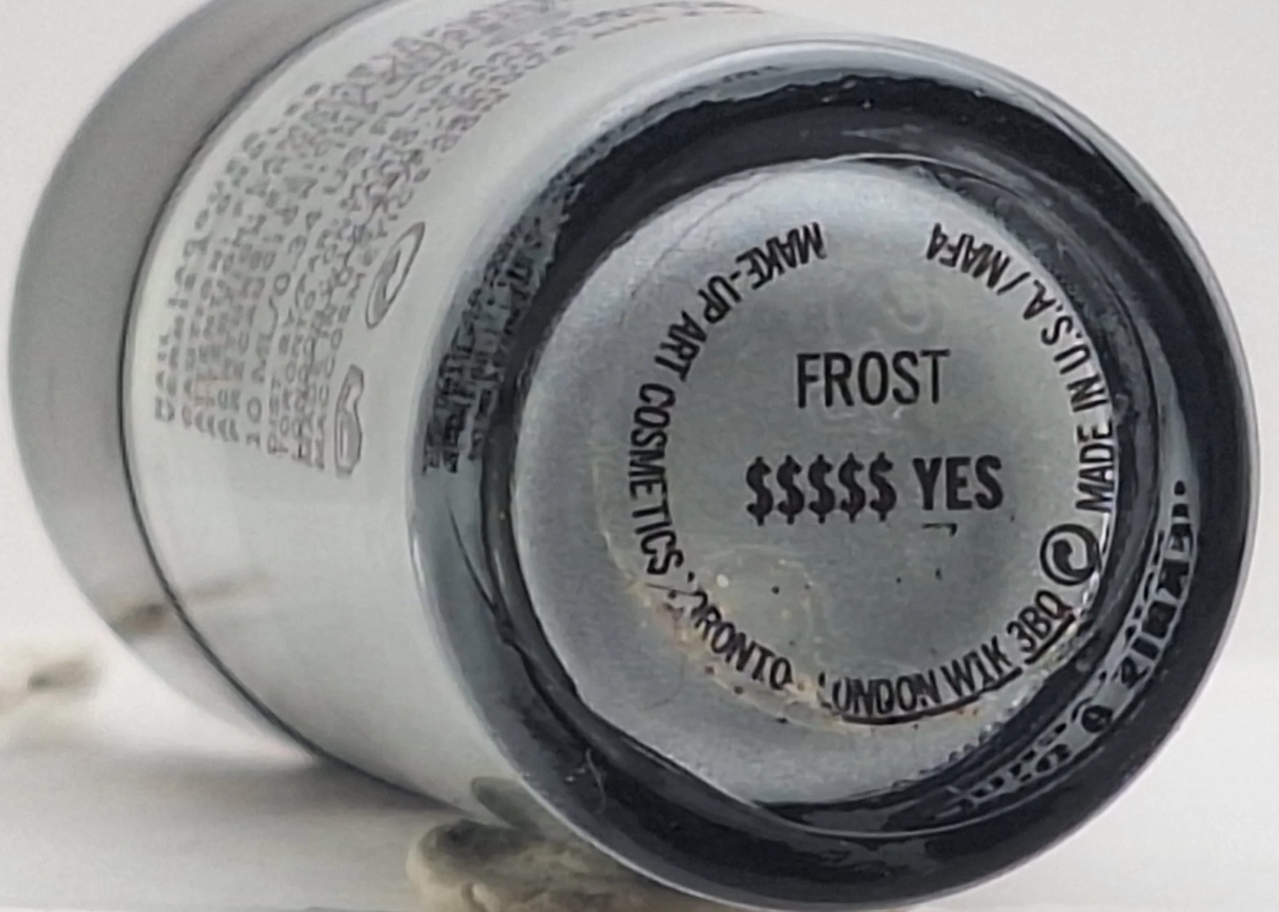 ‘Close−up of the MAC Heatherette nail polish bottom with label reading" YES."`