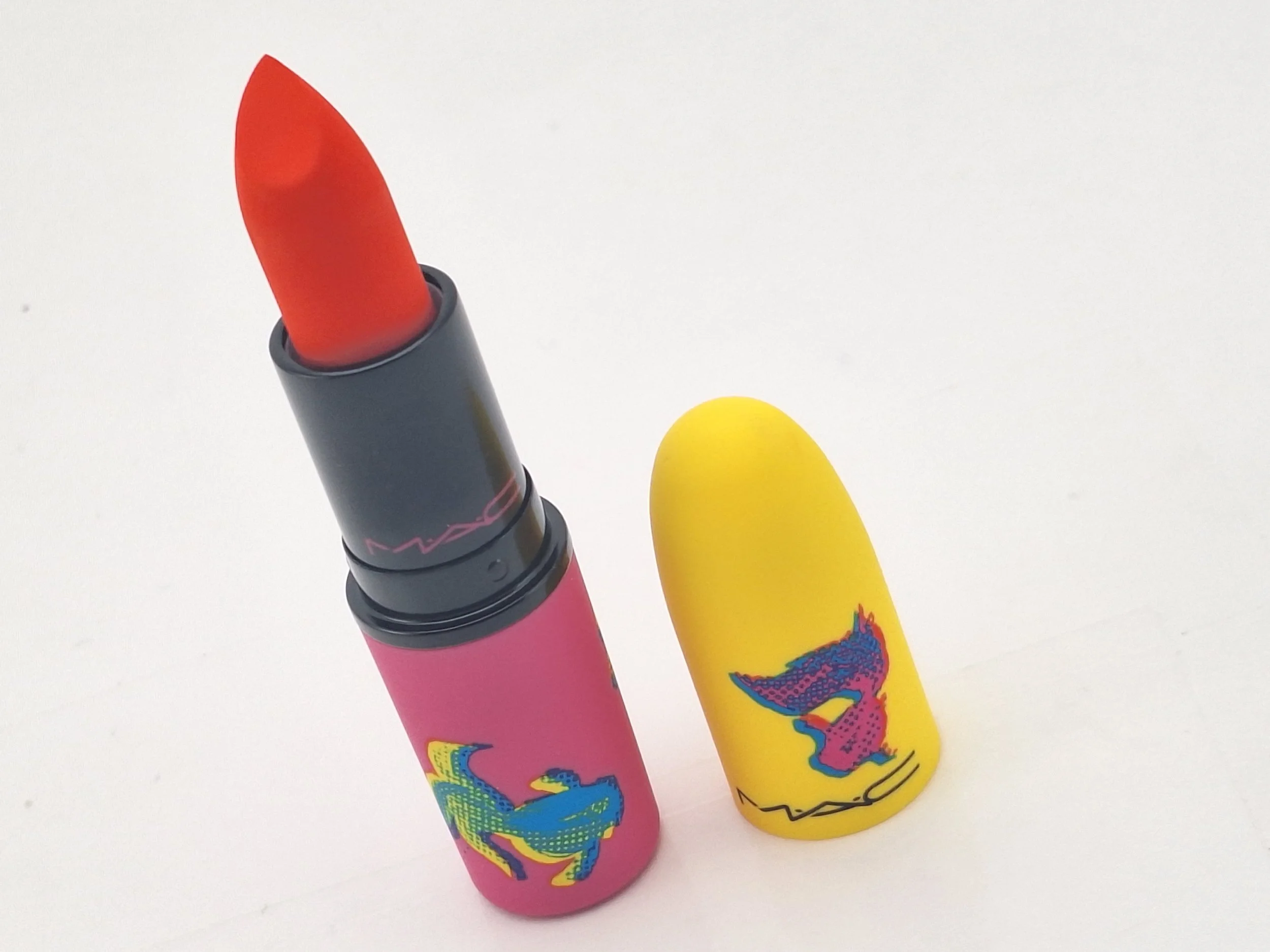 Close-up of Plain Koi lipstick bullet and vibrant red and gold limited-edition case
