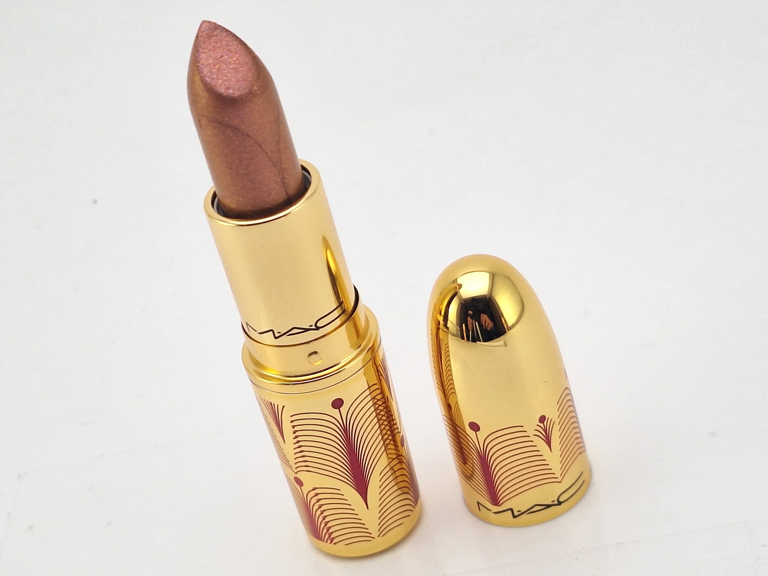 "Close-up of M·A·C Gift of Gold 2024 products with gold-themed packaging."