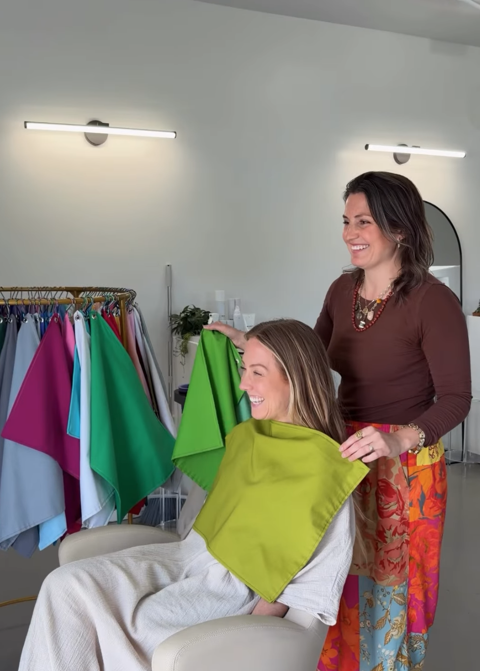 Jess Facey, owner of ŌRA Beauty hair salon in Middletown Rhode Island, getting her color analysis done by Beth of Chromalune while they both are laughing