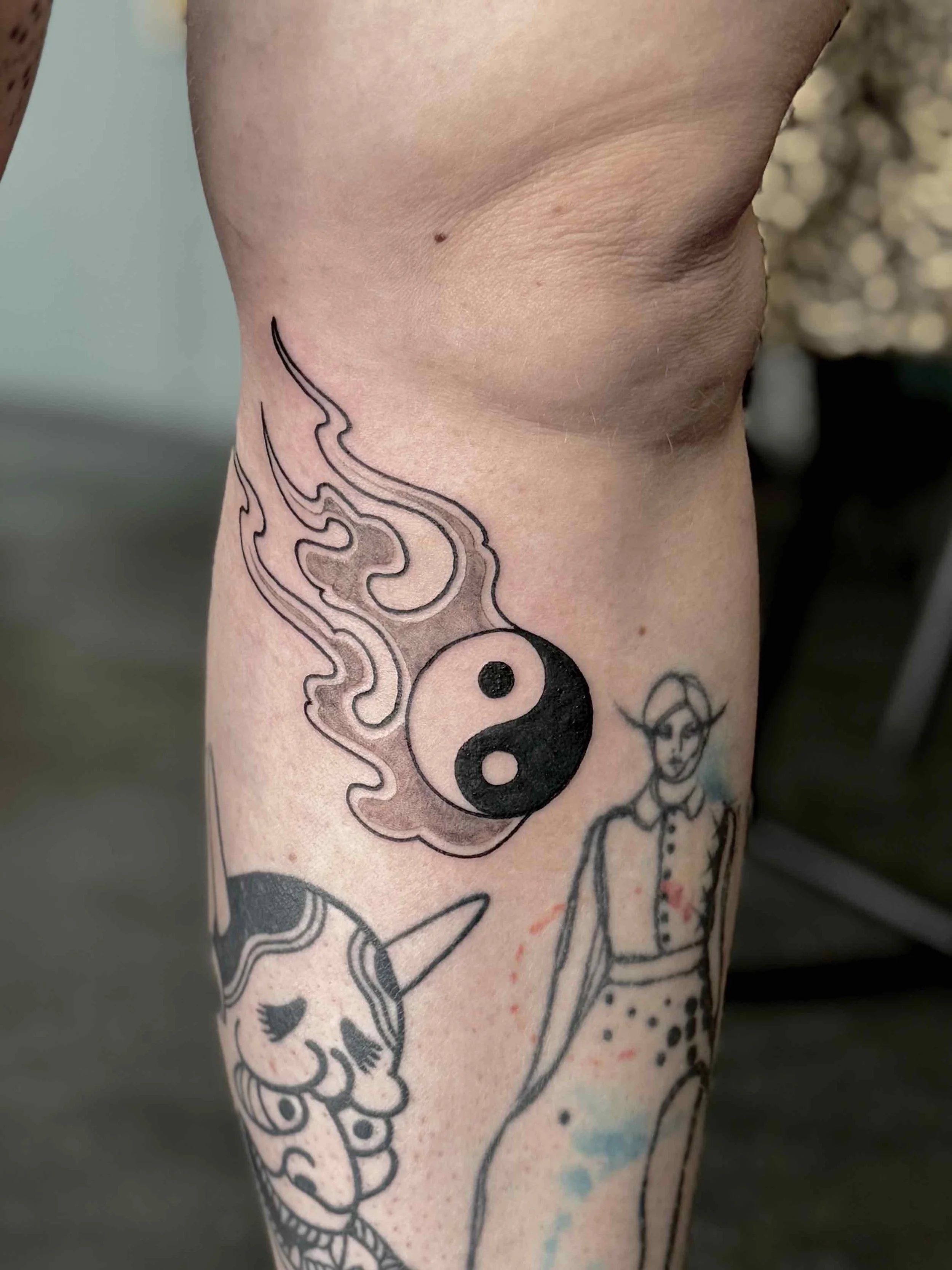 Zwart-wit yin-yang tattoo met vlammen, professioneel gezet door Marcel Tambach bij Se7en Sins Tattoo in Friesland.