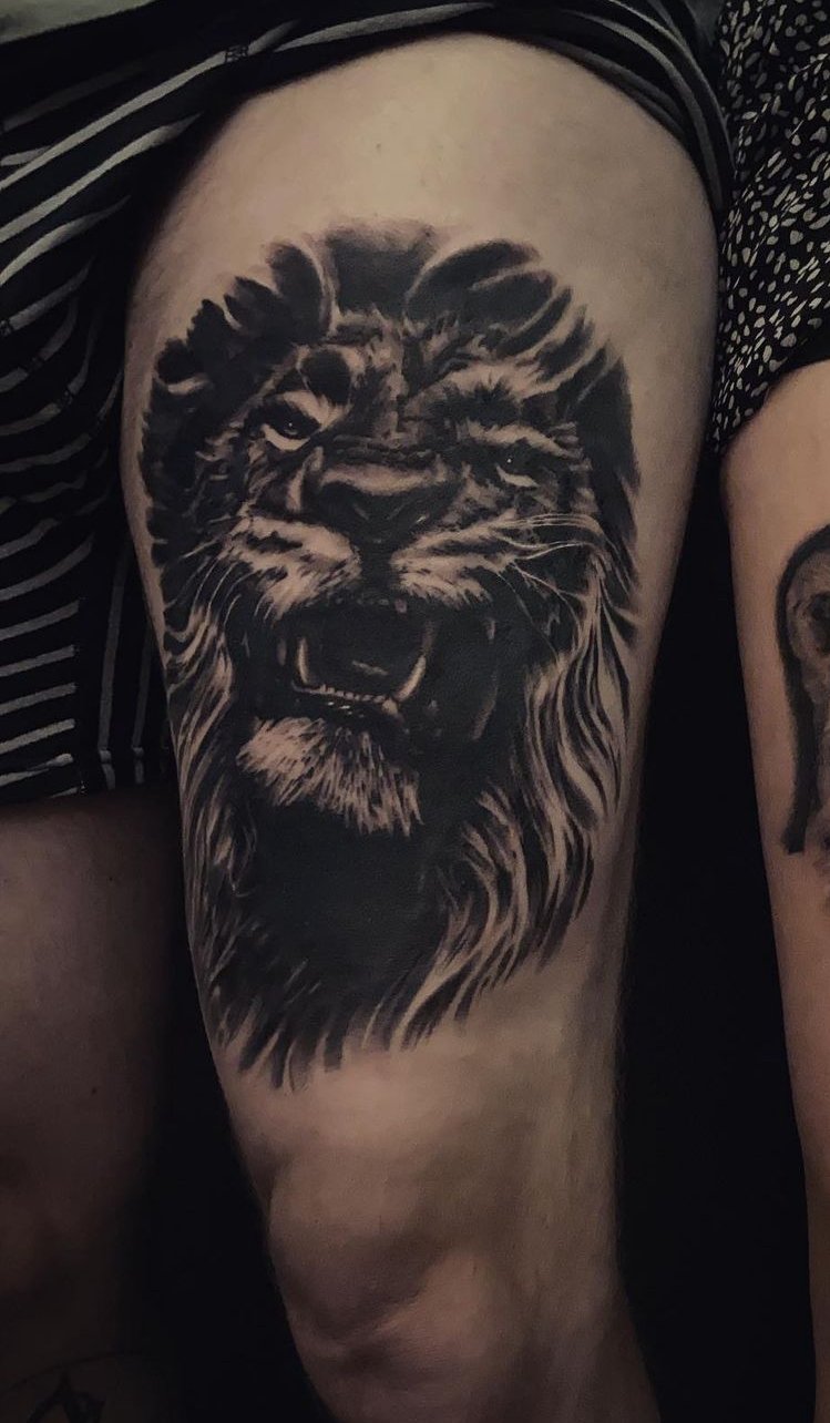 Realistische leeuwenkop-tattoo op bovenbeen gemaakt door Marcel Tambach bij Se7en Sins Tattoo Friesland.