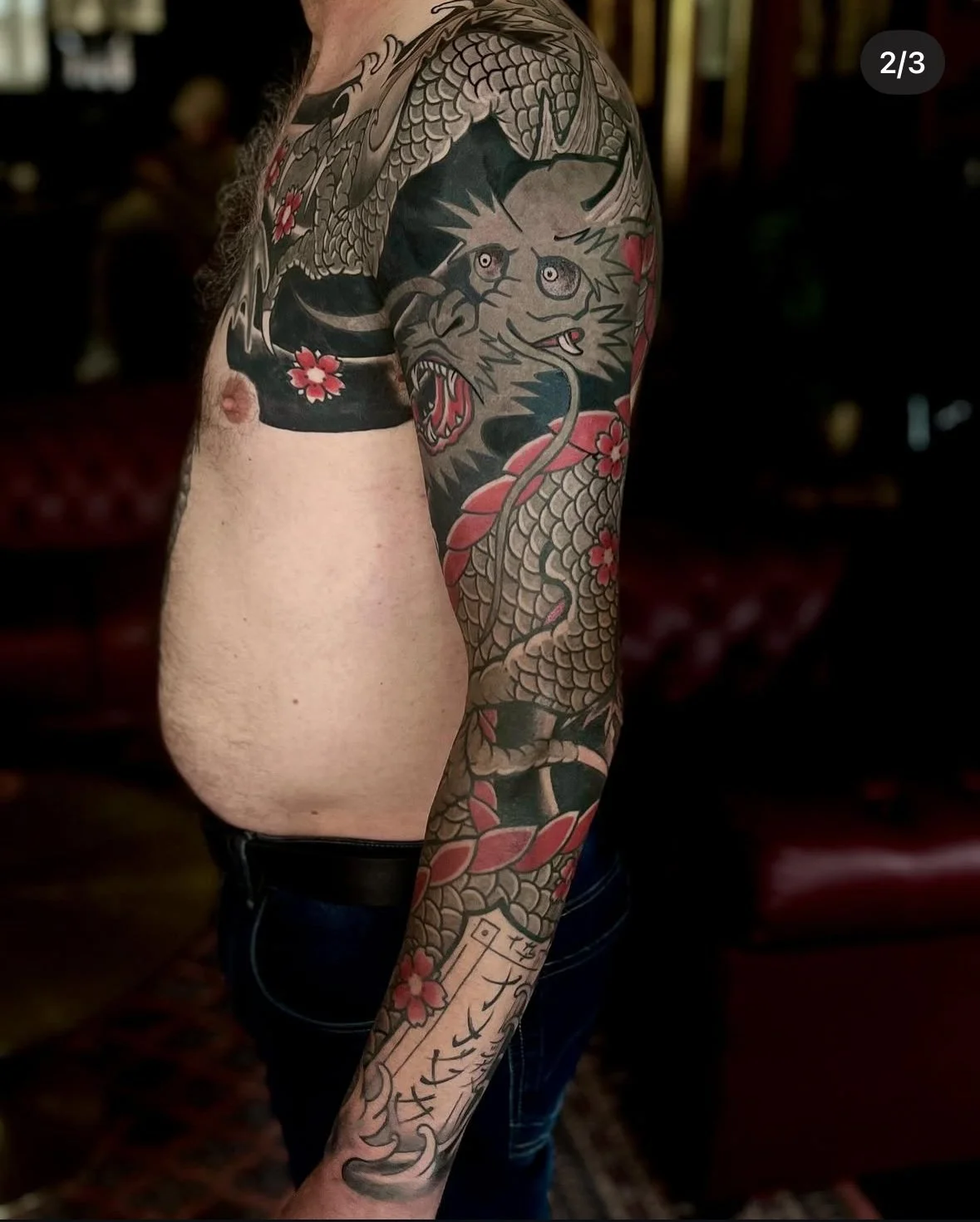 Japanse style tattoo sleeve met drakenkop en traditionele Japanse bloemen over schouder en arm, gemaakt door Marcel Tambach bij Se7en Sins Tattoo Friesland.