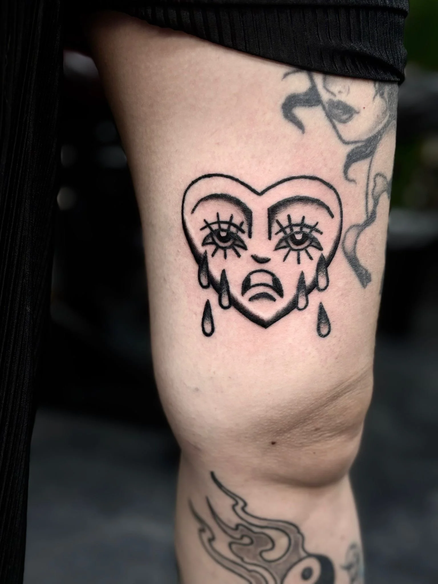 Old school tattoo van een huilend hartje met gezicht en schaduwwerk, gemaakt door Jurjen Wielenga bij Se7en Sins Tattoo nabij Sneek en Heerenveen.