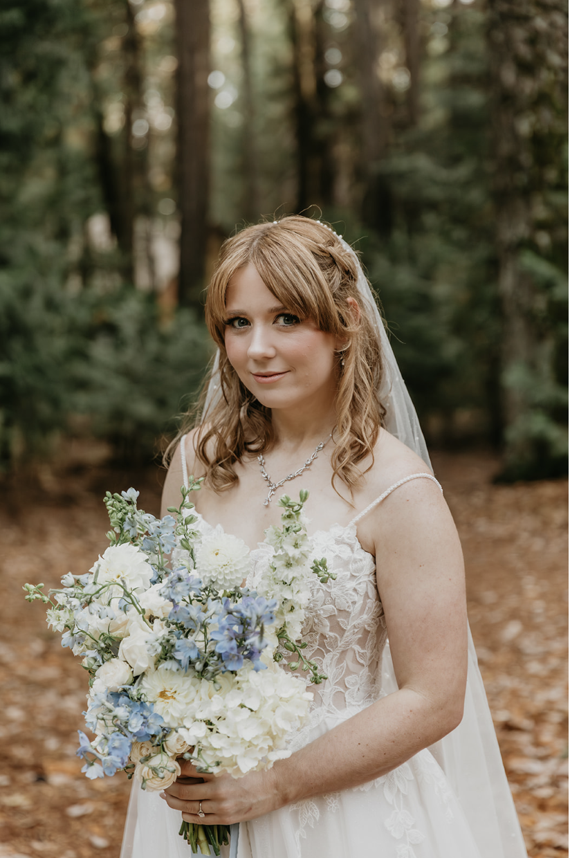 Bride in Lake Tahoe with white and blue bouquet 