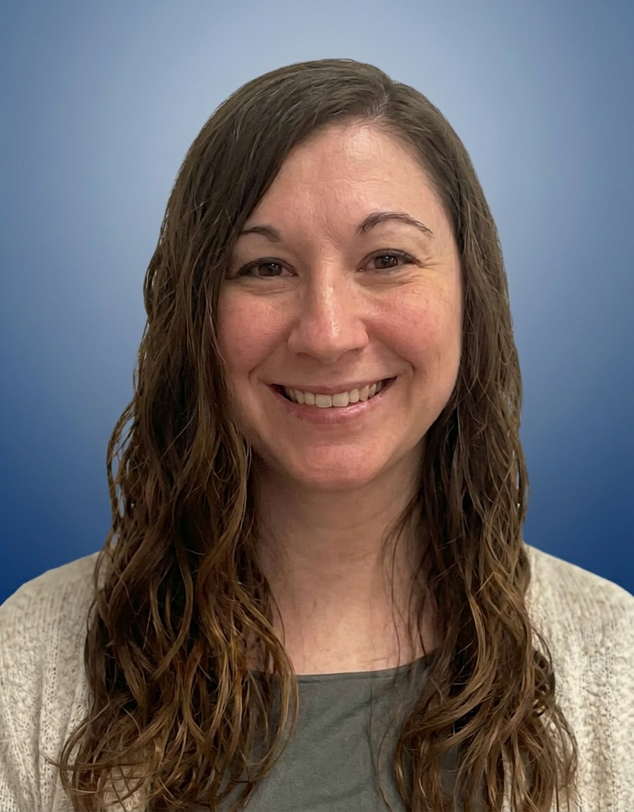 A smiling woman with shoulder-length wavy brown hair, wearing a light-colored sweater over a top, posed against a smooth bluish gradient background