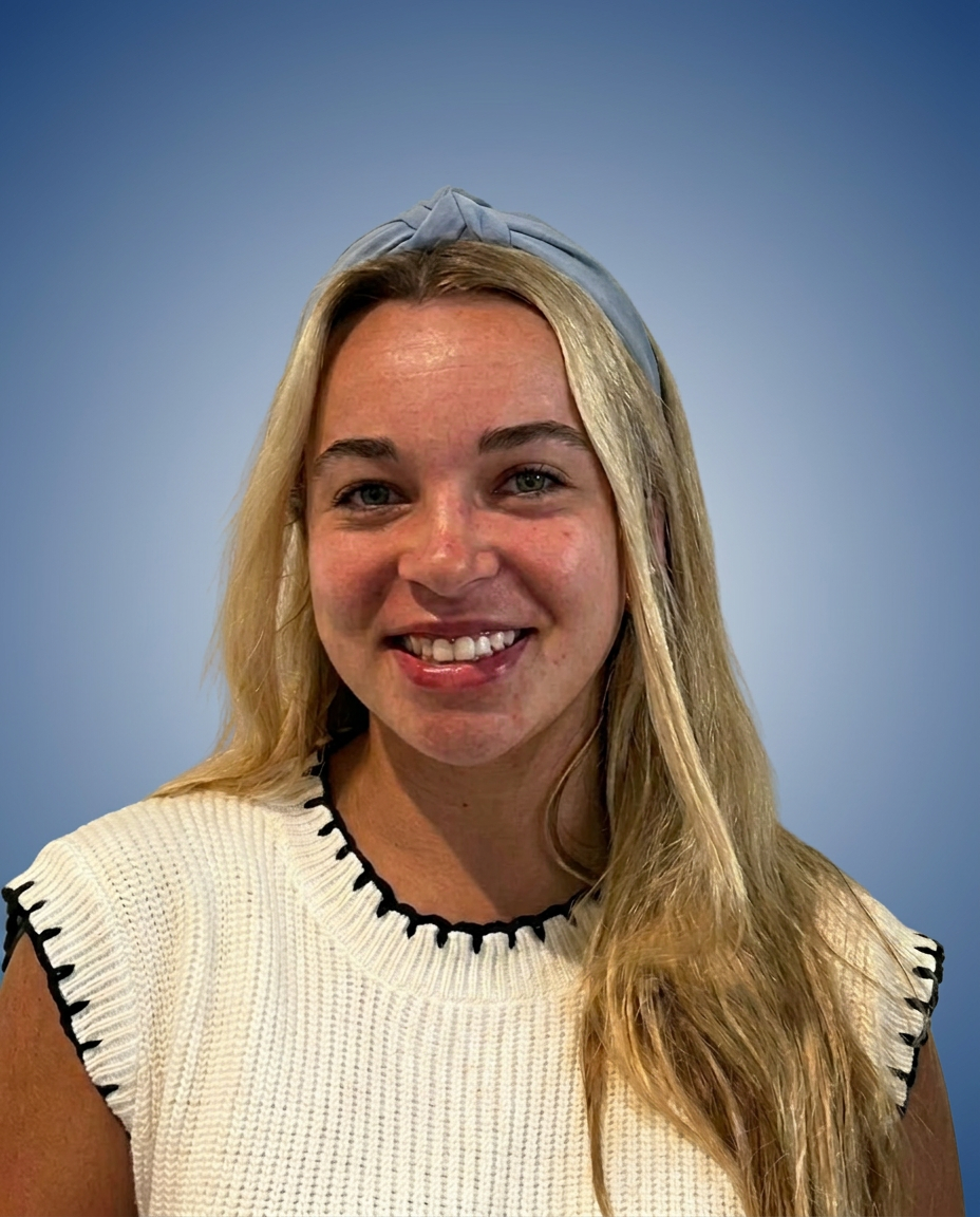 A smiling young woman with long straight blonde hair, wearing a white  knit top with black trim