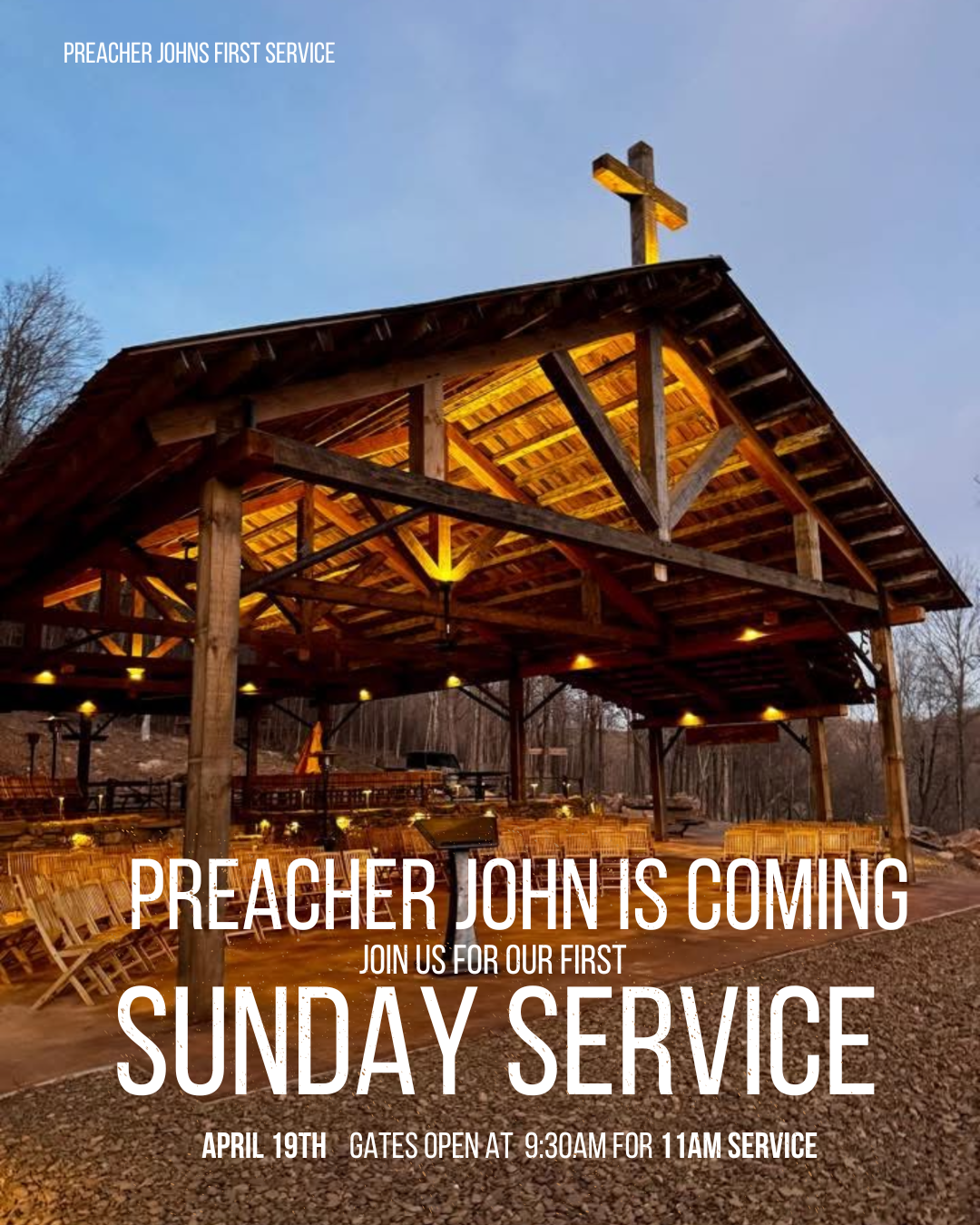 A wooden church pavilion with a cross on top, illuminated with yellow lights during twilight, announcing a church service event in front of a wooded area.