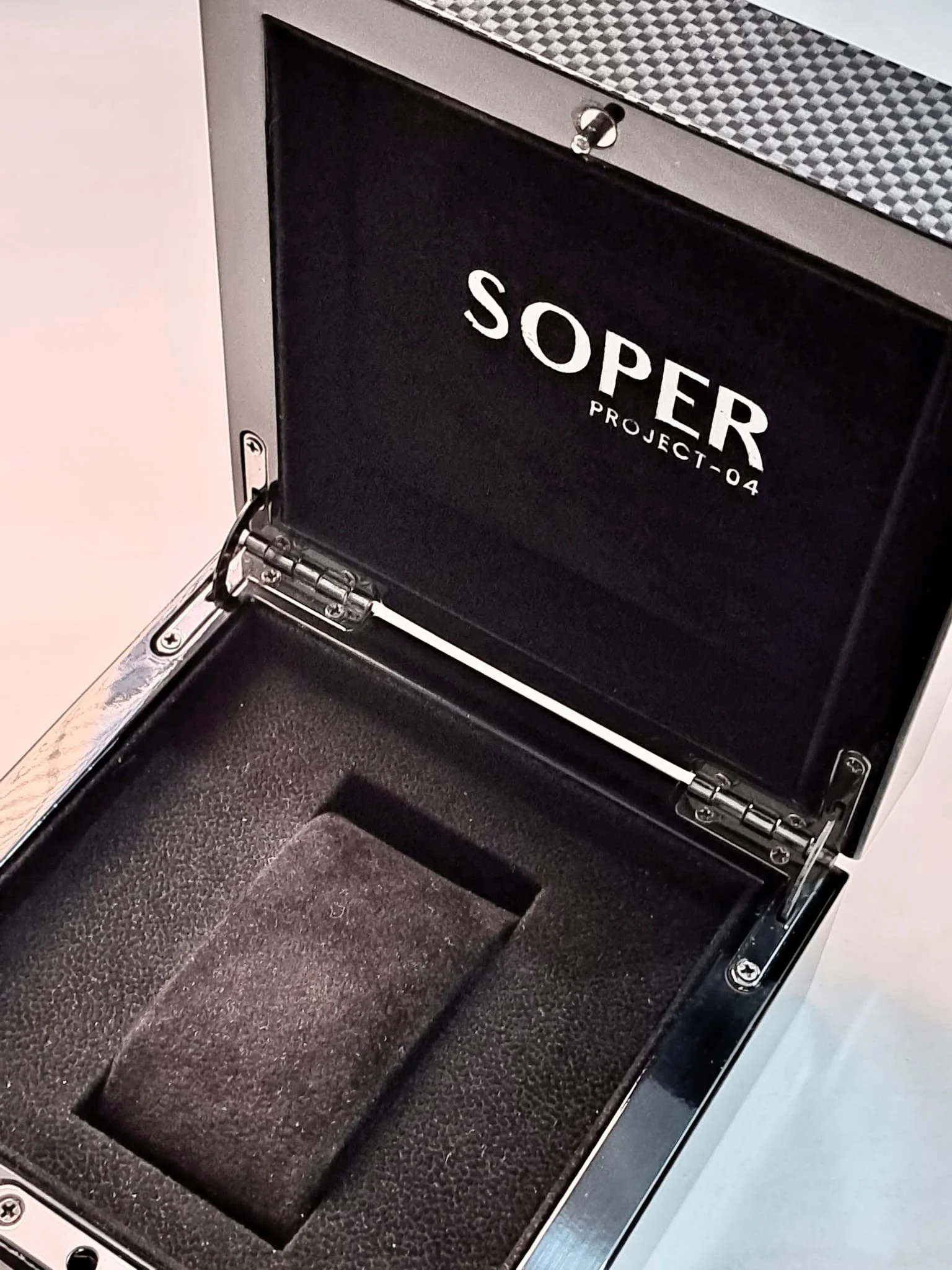 Box nero aperto con interno rivestito in schiuma, etichetta 'SOPER PROJECT-04' sulla parte interna del coperchio.