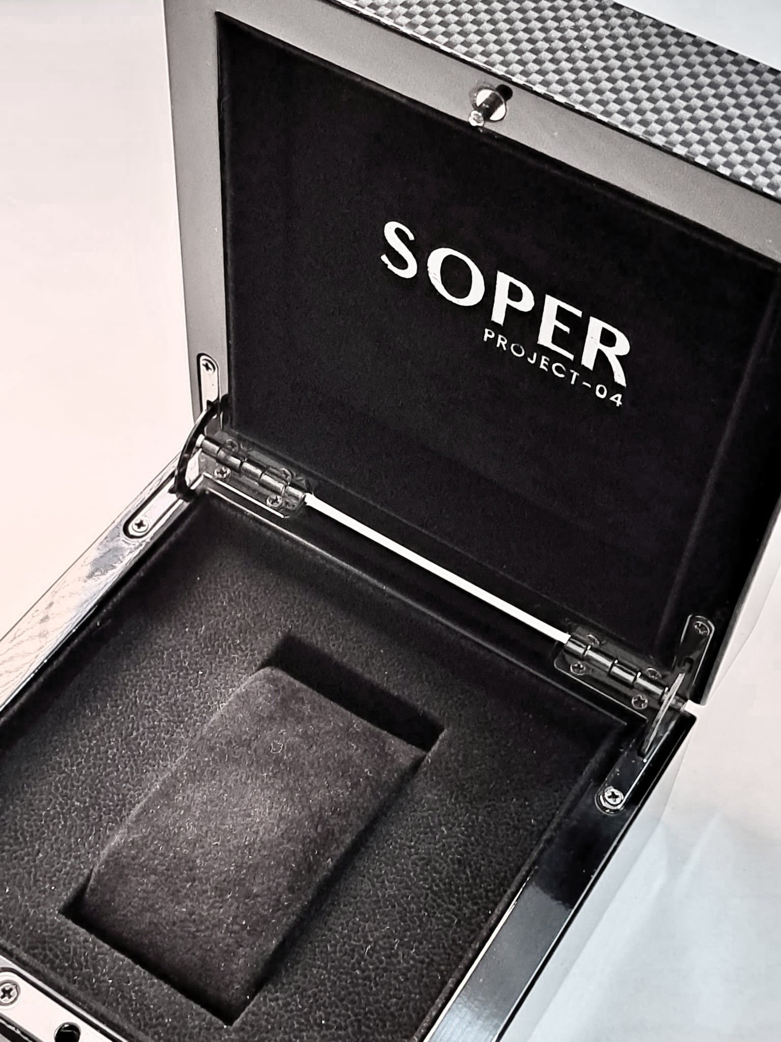 Una valigetta aperta con uno schienale imbottito rivestito di schiuma, marchiata con 'SOPER PROJECT_04'.