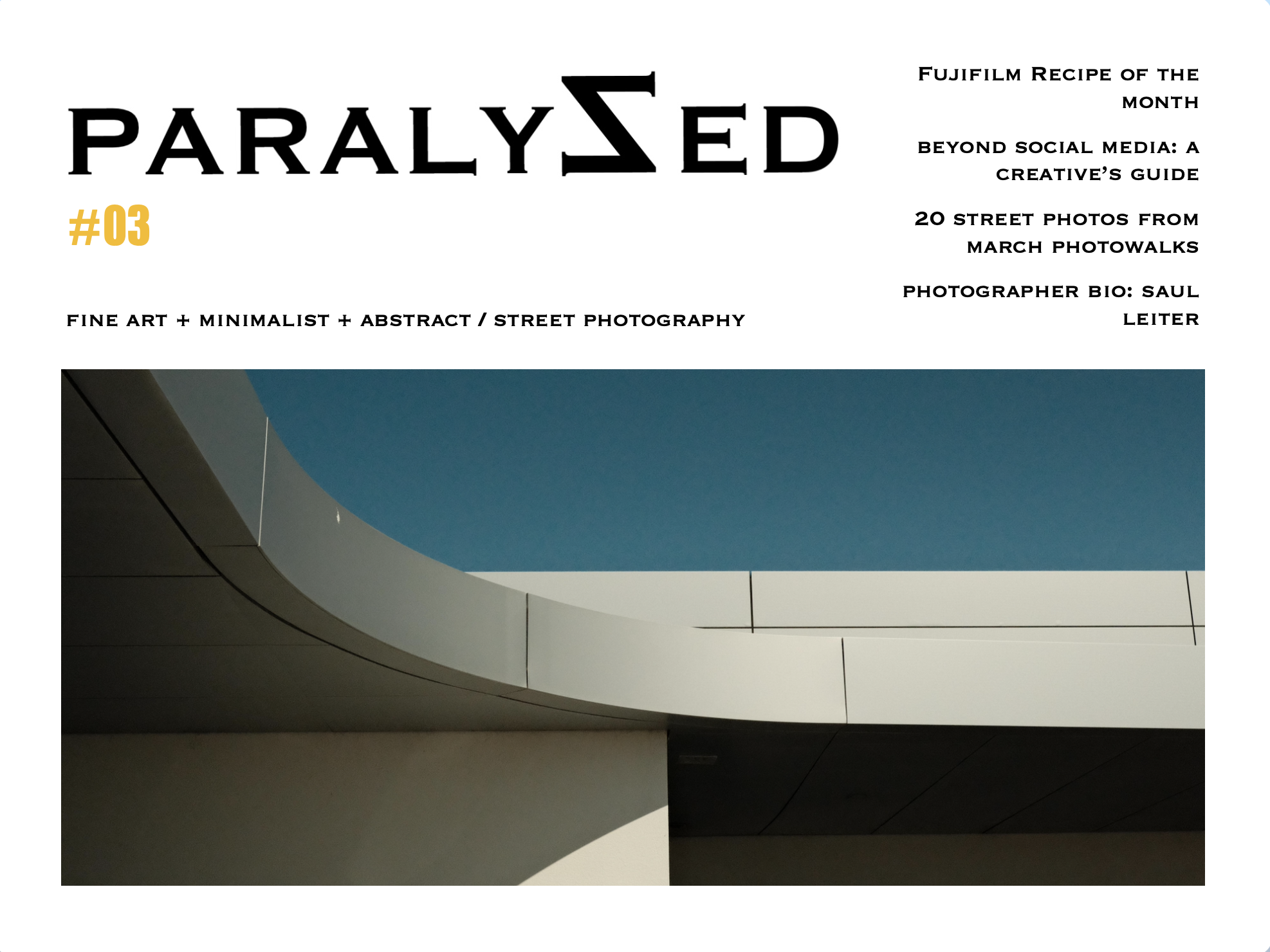Magazine cover with the title 'PARALYZED' featuring minimalist street photography, showing part of a modern building with a curved architectural element against a blue sky.