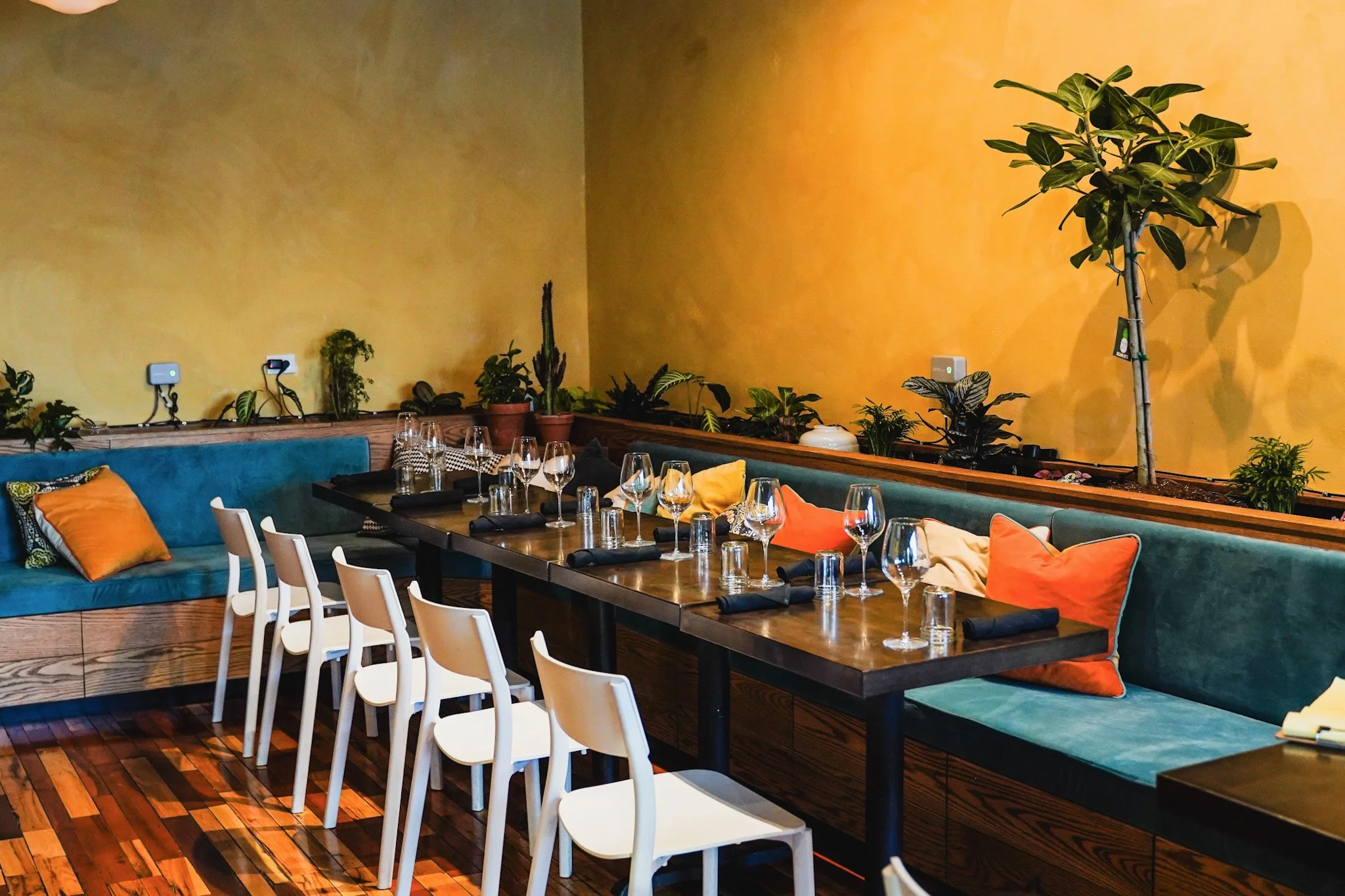 View of the private dining room, bench seating, table dressed, warm light