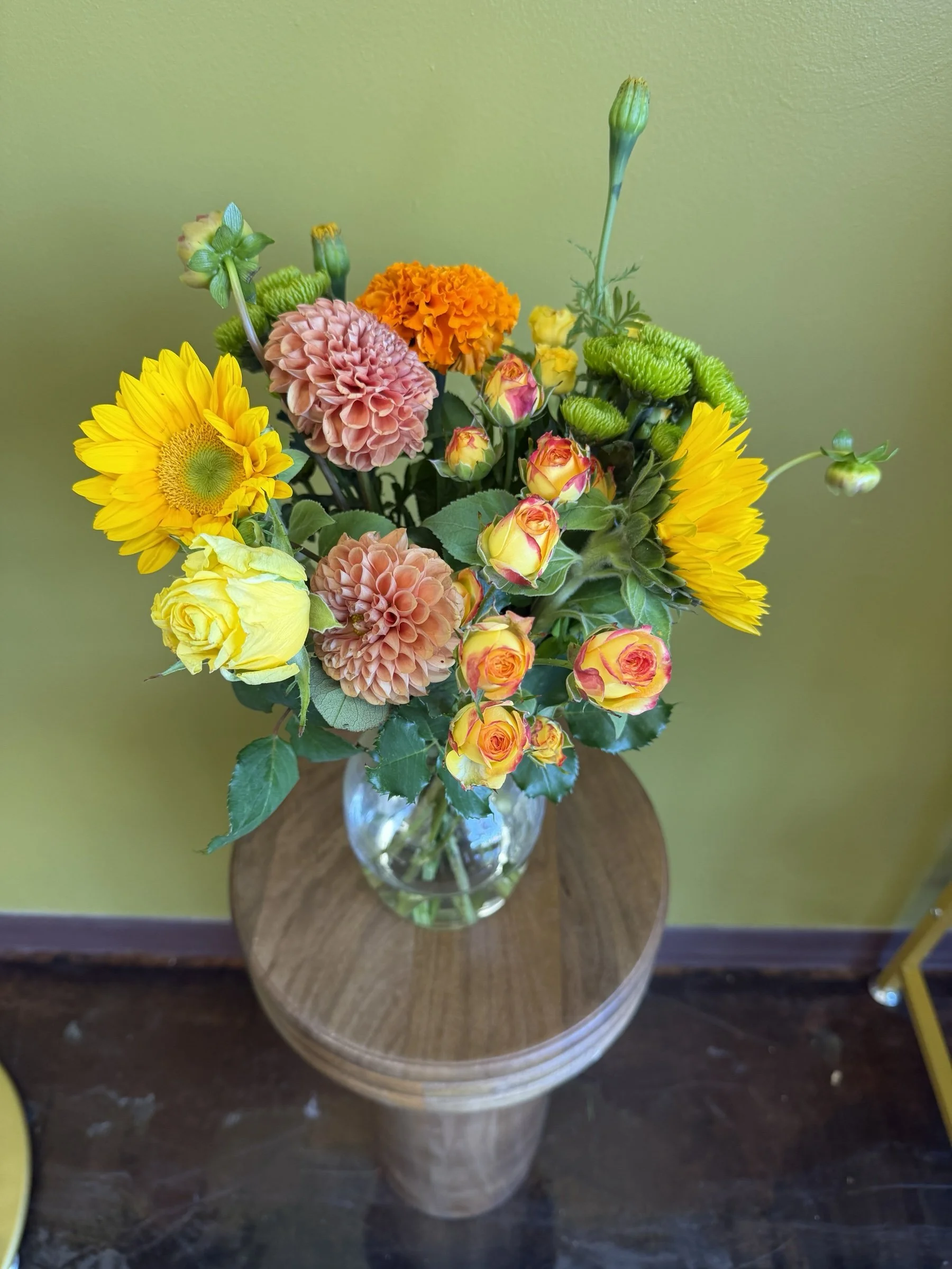 Colorful vase arrangement with sunflowers, dahlias, roses and greenery at The Strike Team Flowers in Concord.
