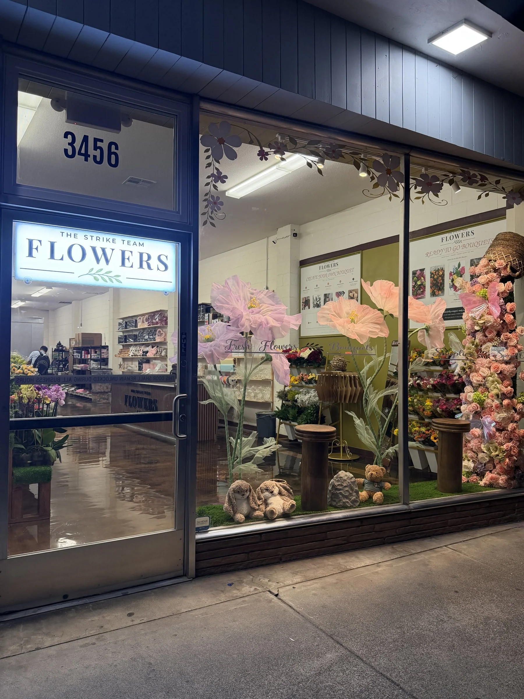 The Strike Team Flowers storefront at 3456 Clayton Road in Concord, with the illuminated Flowers sign and shop entrance.