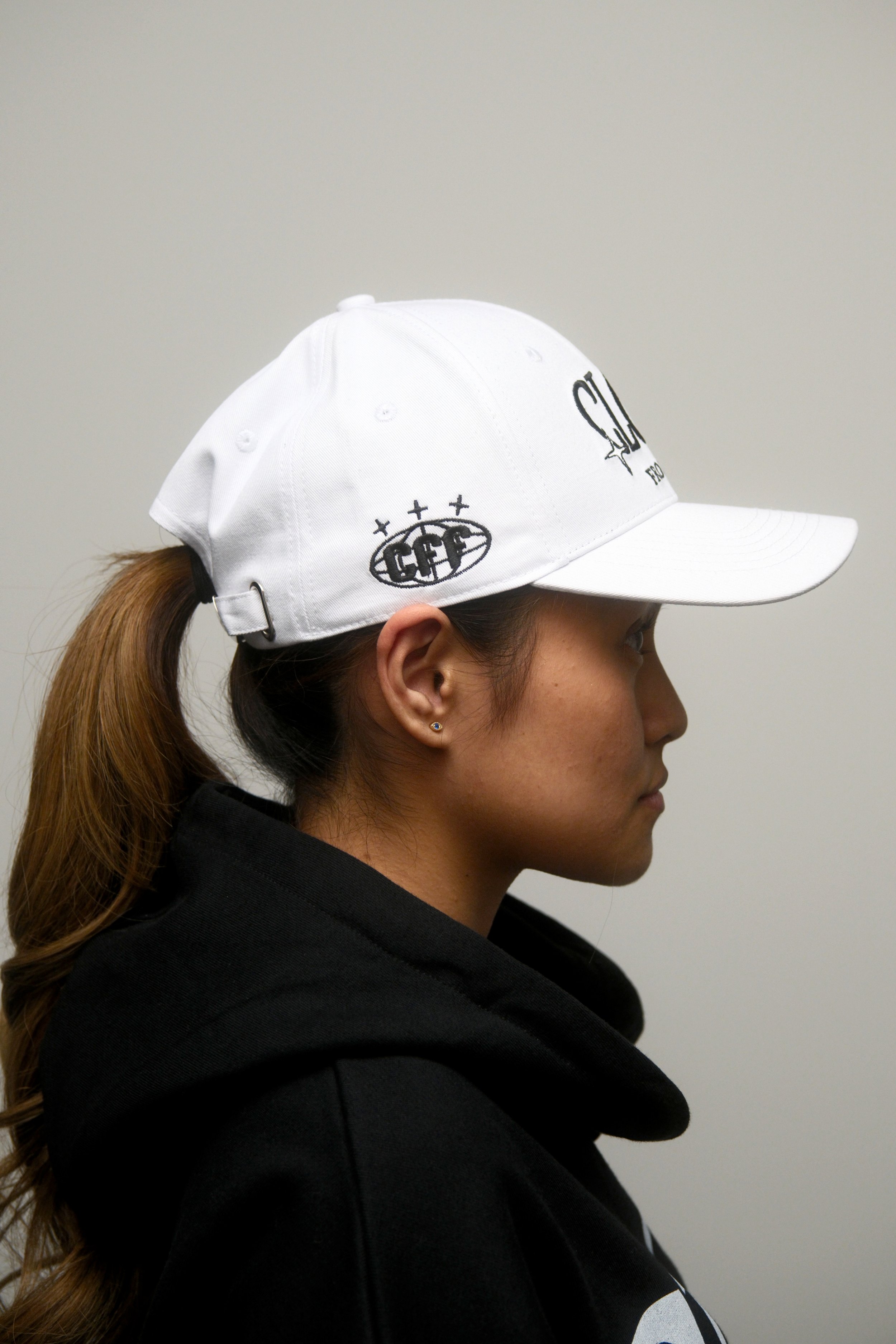 Female Model wearing a Two Stared Close From Far White Cap, Looking Side Ways