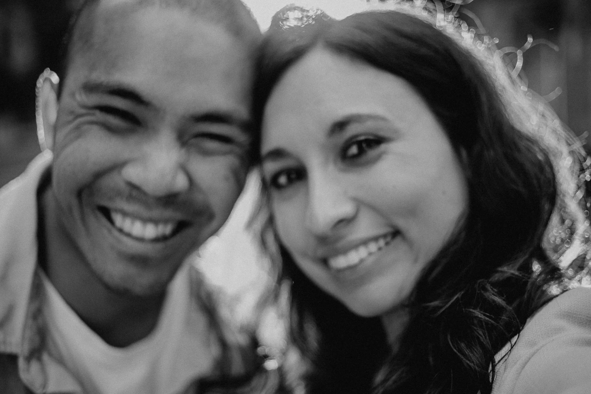Ein Schwarz-Weiß-Bild von zwei lächelnden Personen, wahrscheinlich in einer Nahaufnahme aufgenommen.